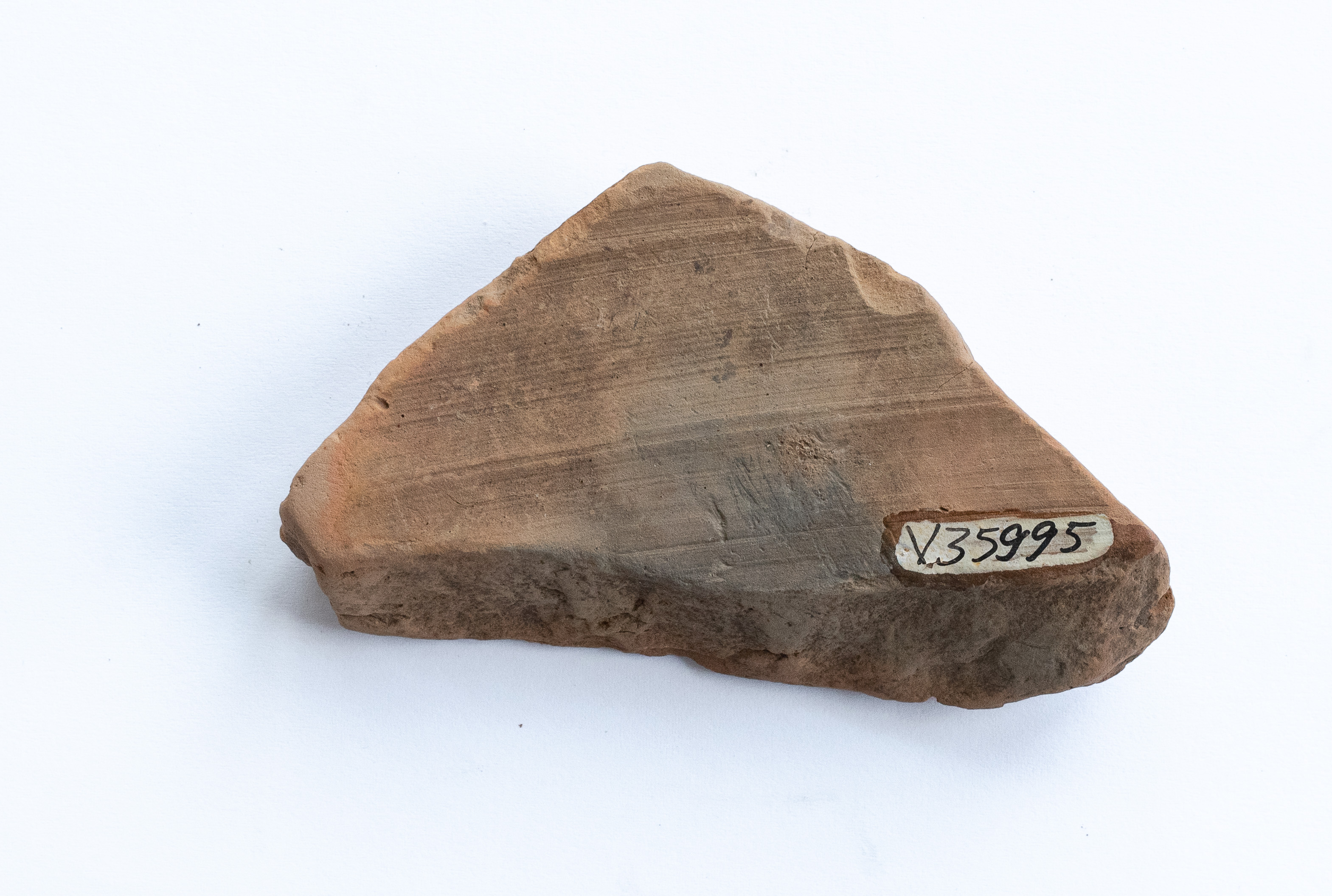 Fragment ceramic ornamentat cu motiv zoomorf?, realizat cu vopsea brun-roșcat pe angobă de culoarea gălbuie; prezintă urme de ardere secundară. Se poate distinge foarte clar faptul că a fost trasat conturul motivului decorativ cu ajutorul un instrument ascuțit, probabil un compas. Tehnica de realizare a fost inspirată de produsele elenistice (stilul Hadra). Motivul decorativ se înscrie în linia stilului figurativ specific ceramicii pictate din zona Sarmizegetusei Regia. Acest vas avea atât rol funcțional, cât și decorativ.