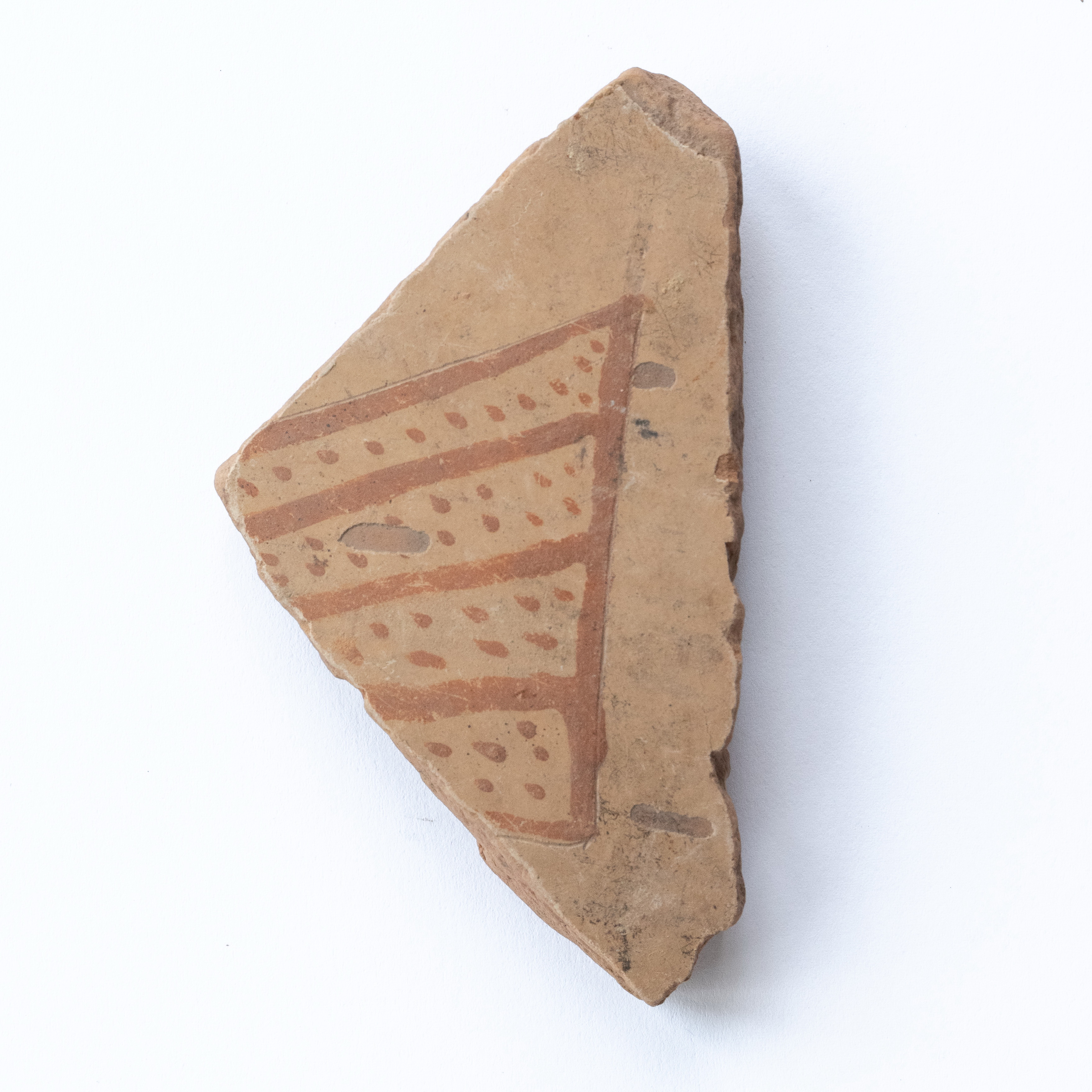 Fragment ceramic ornamentat cu motive zoomorfe, foarte probabil (coada unei păsări?), realizat cu vopsea roșie pe angobă de culoarea alb-gălbuie. Tehnica de realizare a fost inspirată de produsele elenistice (stilul Hadra). Motivul decorativ se înscrie în linia stilului figurativ specific ceramicii pictate din zona Sarmizegetusei Regia. Acest vas avea atât rol funcțional, cât și decorativ.