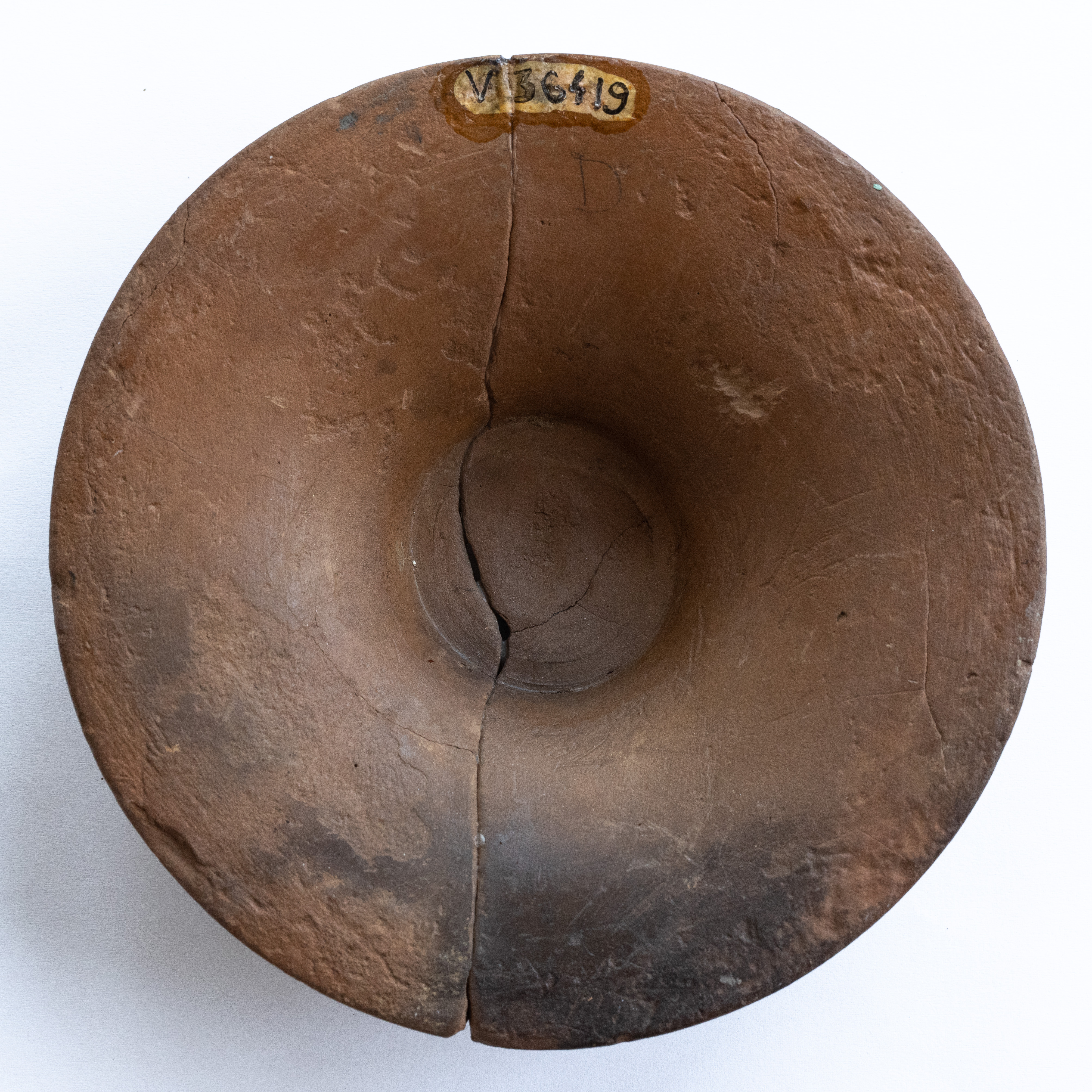 Piedestal de la un vas ceramic, ornamentat cu motive geometrice (triunghiuri umplute cu puncte), realizat cu vopsea brun-roșcată pe angobă de culoarea gălbuie; prezintă urme de ardere secundară. Tehnica de realizare a fost inspirată de produsele elenistice (stilul Hadra). Motivul decorativ se înscrie în linia stilului figurativ specific ceramicii pictate din zona Sarmizegetusei Regia. Acest vas avea atât rol funcțional, cât și decorativ.