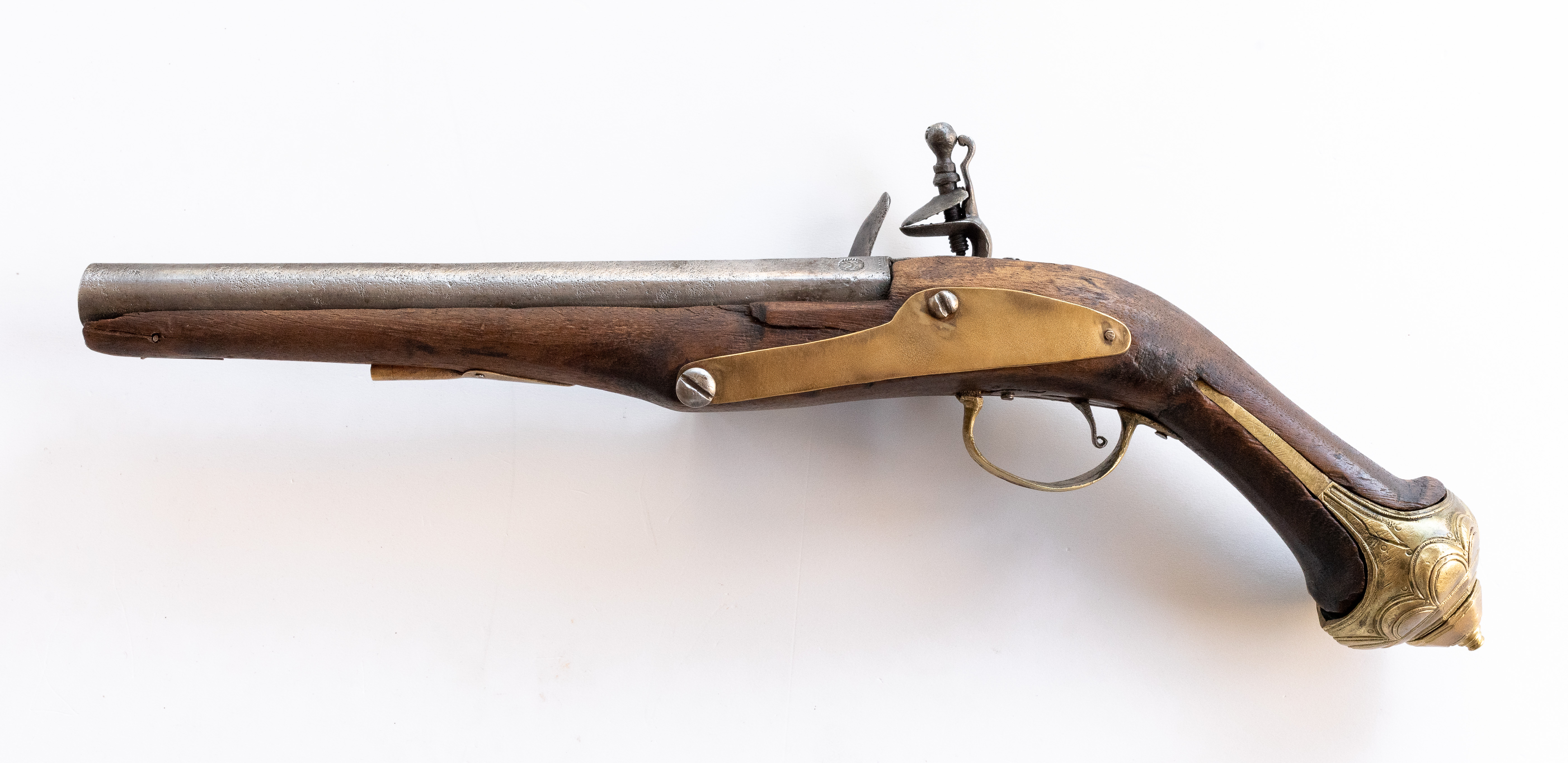 Pistol cu cremene, cu mecanismul de dare a focului complet. Țeava este așezată pe ulucul de lemn simplu, nedecorat, prevăzut cu un inel de aramă pentru bătător. Pe partea stângă a pistolului există o aplică de aramă de formă sinuoasă, fixată în două locuri cu șuruburi ulterioare și într-unul cu nitul original. Capătul patului pistolului prezintă o întăritură de aramă cu buton ornamental, decorată prin incizie cu un ornament floral supradimensionat. Țeava pistolului este găurită spre culasă și ștanțată cu patru semne de meșter identice, două aurite, neidentificate.