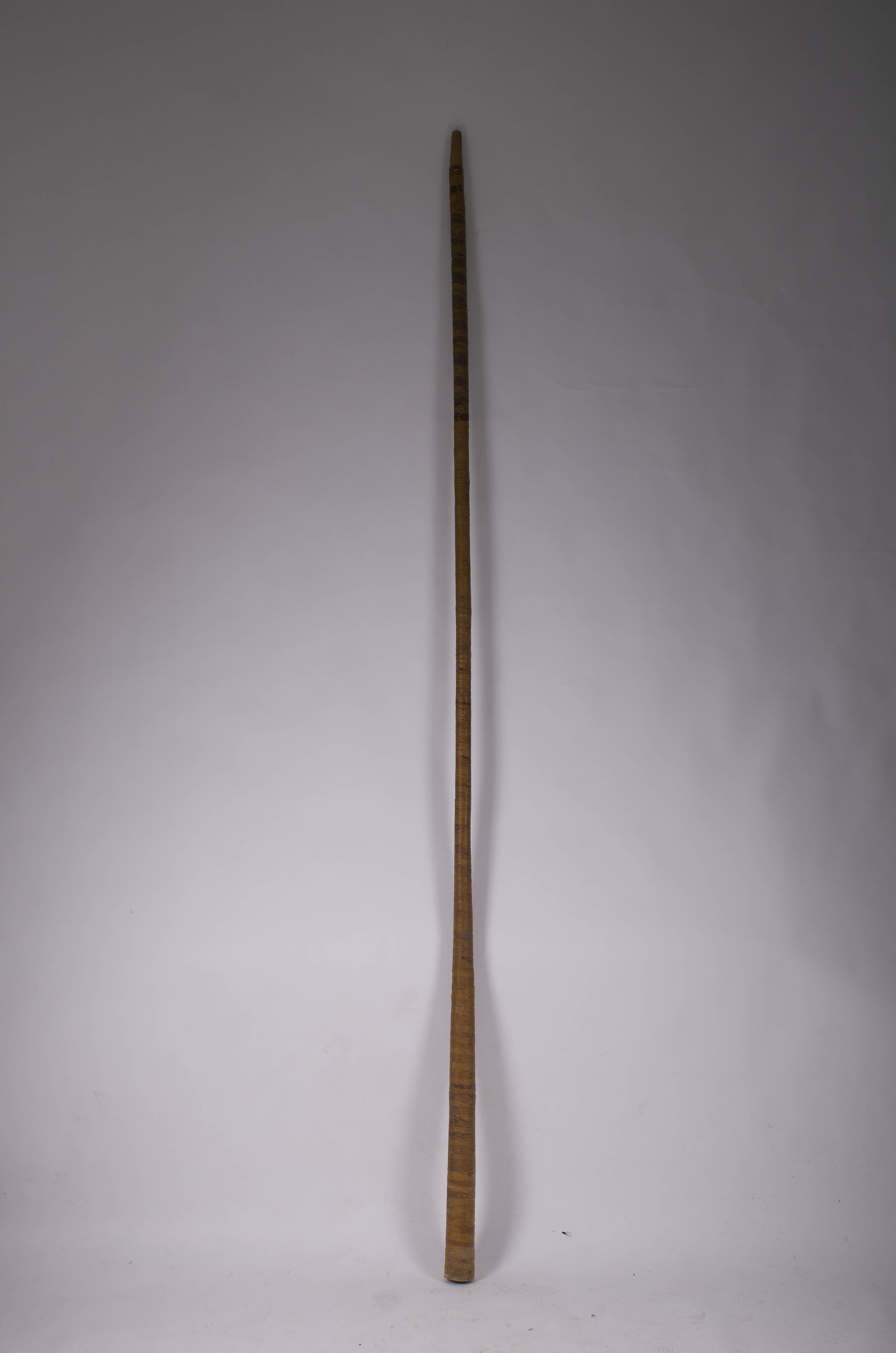 Instrument de suflat de formă tronconică și lungime mare realizat din doage înfășurate în scoarță de copac. Neornamentat. Cromatică: culoarea patinată a lemnului.