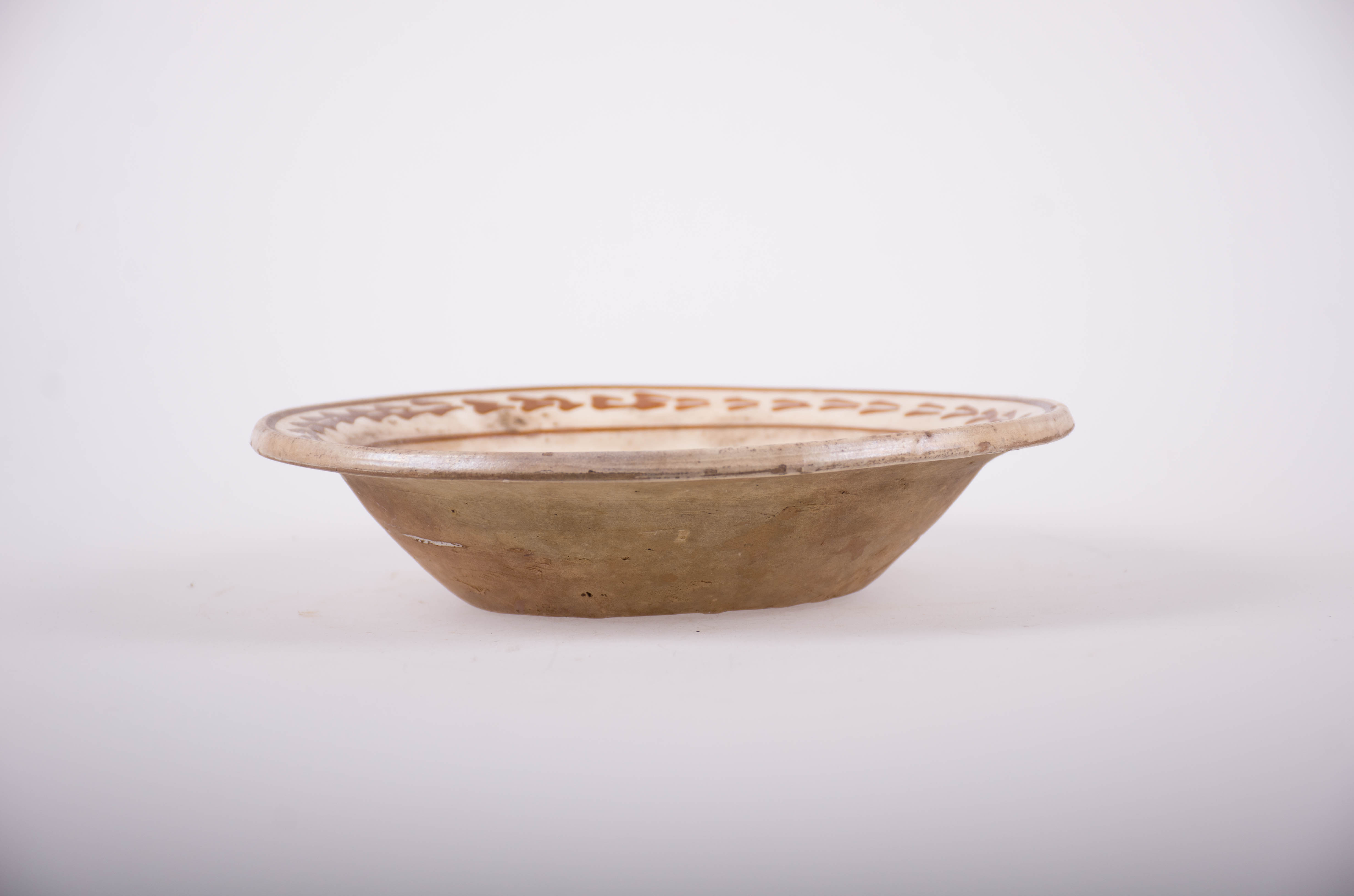 Blid din ceramică smălțuit în interior; decorat cu motive florale si puncte. Cromatică: fond alb-galbui; motive: maro; albastru; verde.