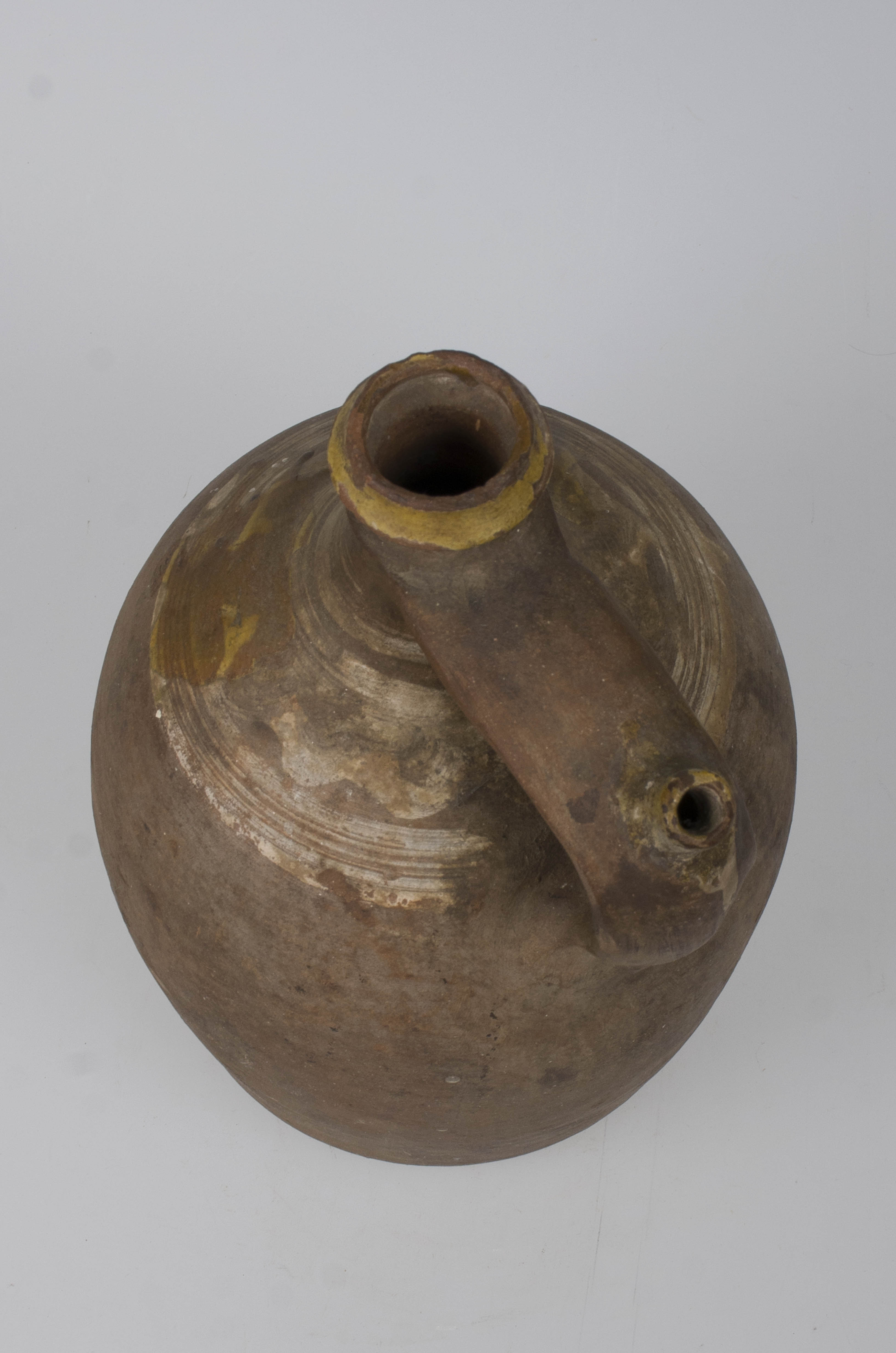 Recipient ceramic cu corpul puternic bombat, ovoidal , având un gât alungit și buza profilată. Din zona mediană a gâtului pornește o toartă aplatizată prevăzută cu o țâță. Motivele decorative se identifică la baza gâtului. Prezintă motive geometrice; cercuri concentrice și motive florale stilizate. Prezintă urme de vopsea cu rol decorativ. Decorul este realizat prin pictare și stropire. Are rol de depozitare, transport lichide. Cromatică: maro; alb (motive).