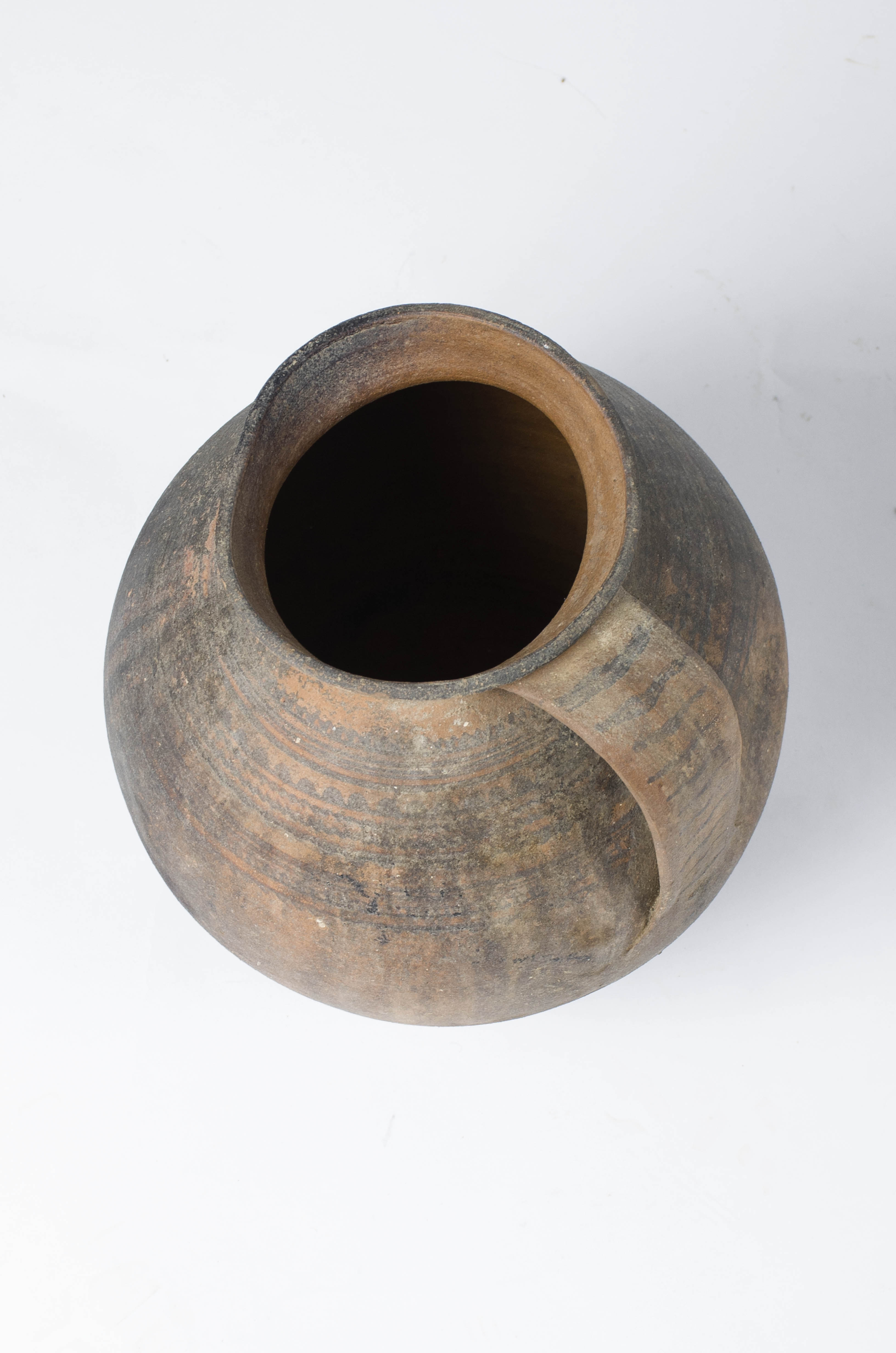 Vas ceramic de mari dimensiuni, bitronconic, prevăzut cu o toartă și realizat la roata olarului, uscat, pictat și apoi ars. Deși nesmălțuit, vasul prezintă un decor complex, în mod special în partea superioară, compus din trei registre formate din linii concentrice drepte și în valuri, de culoare neagră. Toarta este și ea ornamentată, cu linii drepte de culoare neagră. Buza vasului prezintă o „îndoitură” vis-a-vis de toartă, cauzată cel mai probabil de manipularea vasului înainte de uscare și ardere.