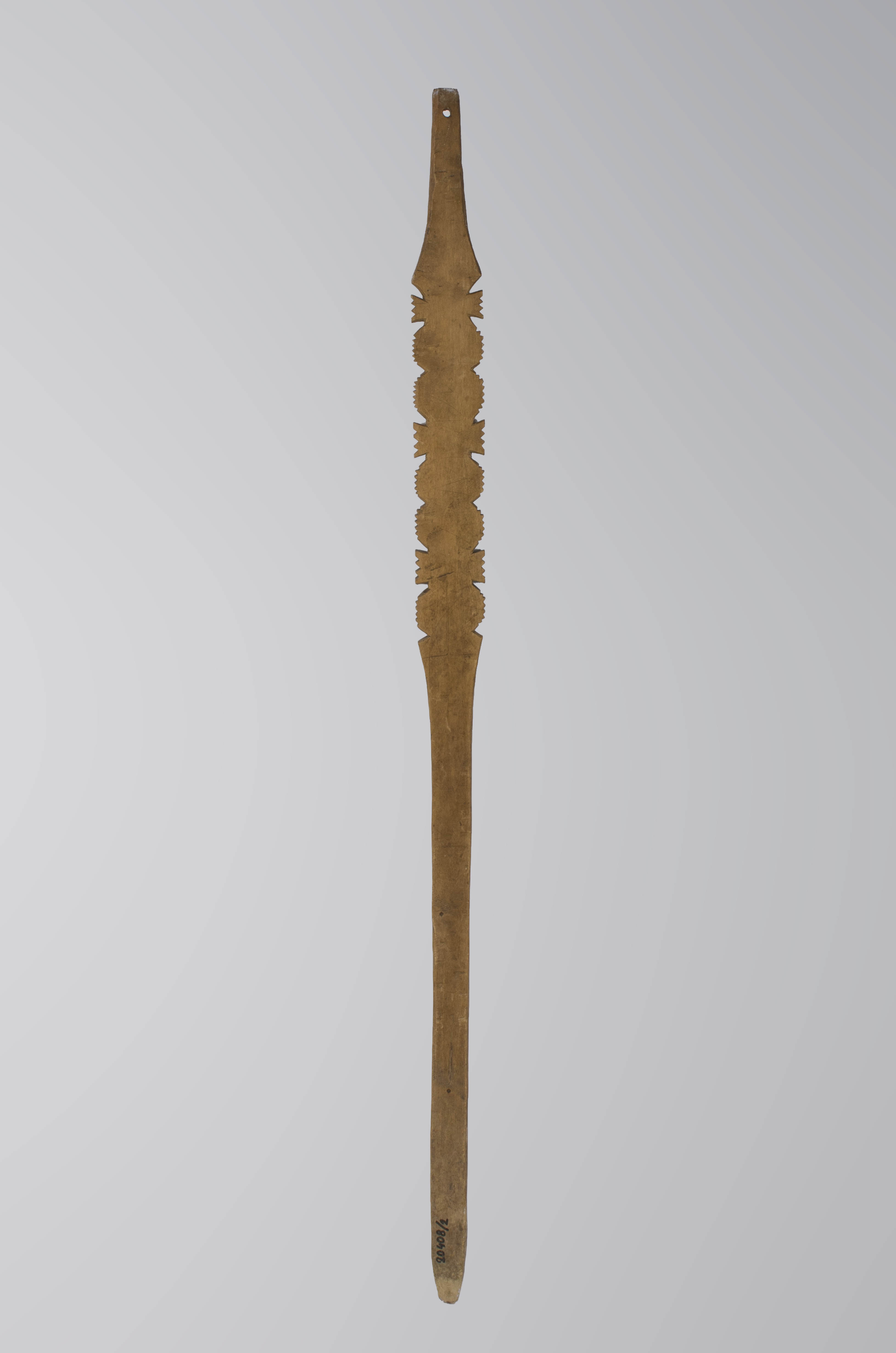 Furcă de tors de formă fusiformă, puțin aplatizată. Partea mediană este decorată cu forme geometrice stilizate (cercuri, colțuri, muchii neregulate) realizate prin sculptare. Toate aceste forme prezintă periferic o multitudine de zimți. Partea superioară a furcii prezintă un orificiu circular pentru agățare. Pe partea lată, care susține caierul se distinge schița unui desen din creion (cruci, litere, linii paralele). Cromatică: maro-deschis.