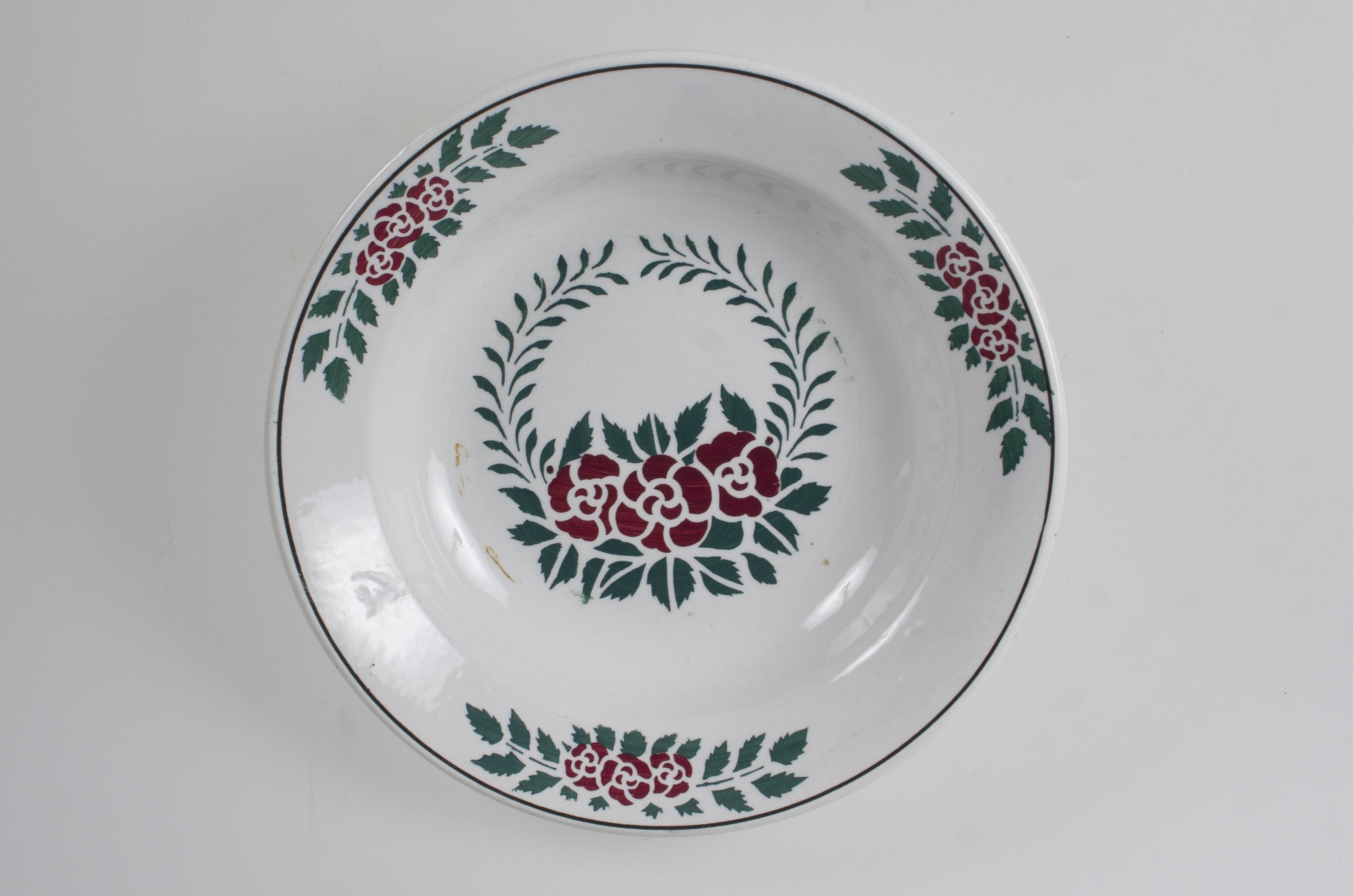 Vasul are formă tronconică, adâncită. Este decorat cu motive florale, vegetale și geometrice; are trei flori pe margine ce sunt delimitate de o linie; în centru este decorat cu un buchet format din trei trandafiri; pe fund are trei cercuri concentrice. Vasul este smălțuit interior-exterior. Cromatică: fond alb; motive: verde; roșu.
