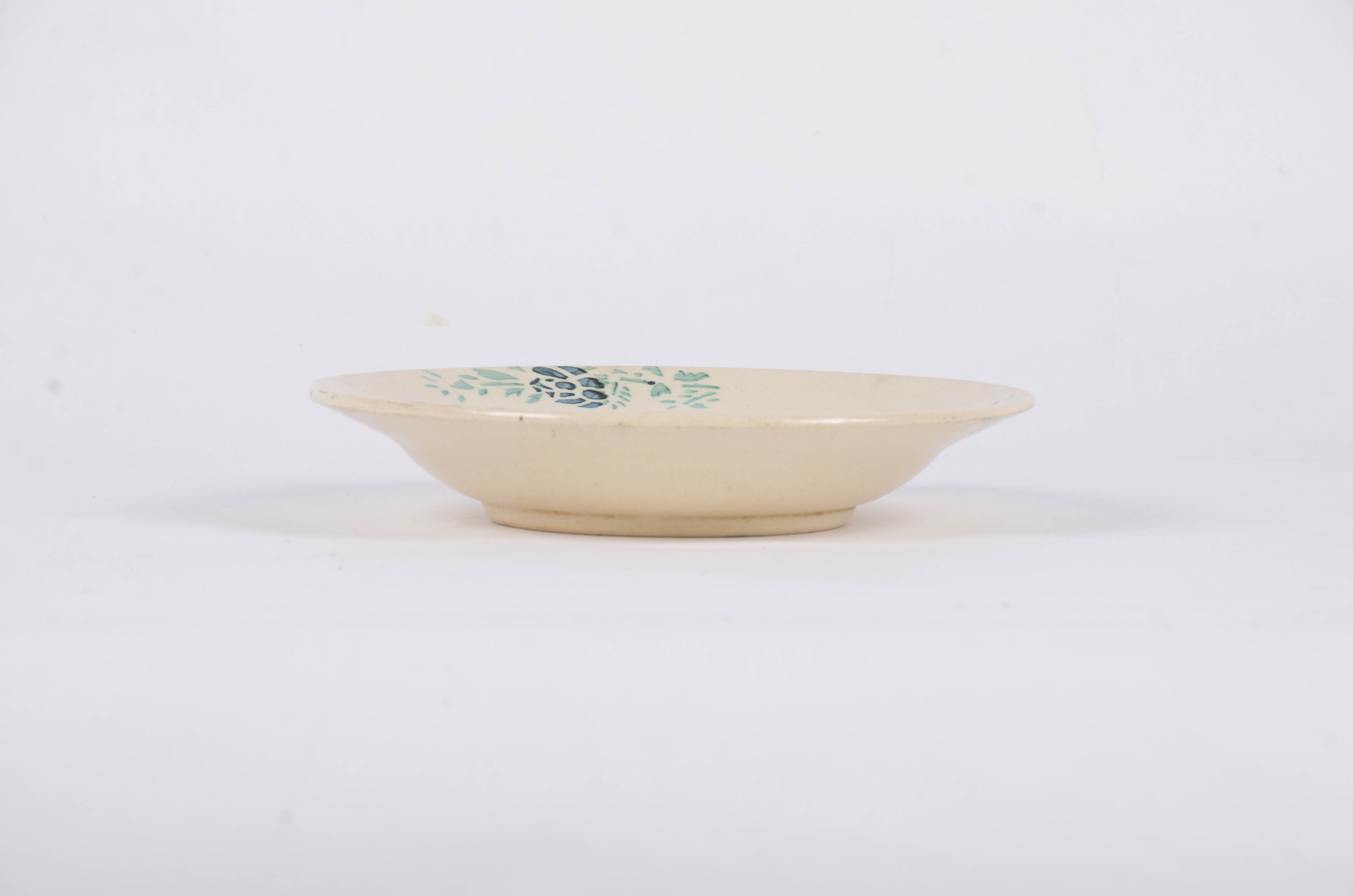 Vasul ceramic este de formă tronconică fiind decorat cu motive florale dispuse central sub forma unui buchet de flori, iar pe marginea farfuriei sunt dispuse într-un registru circular motive floral-vegetale pe un fond alb. Frafuria este smălțuită. Cromatică: fond: alb; motive; verde; albastru.