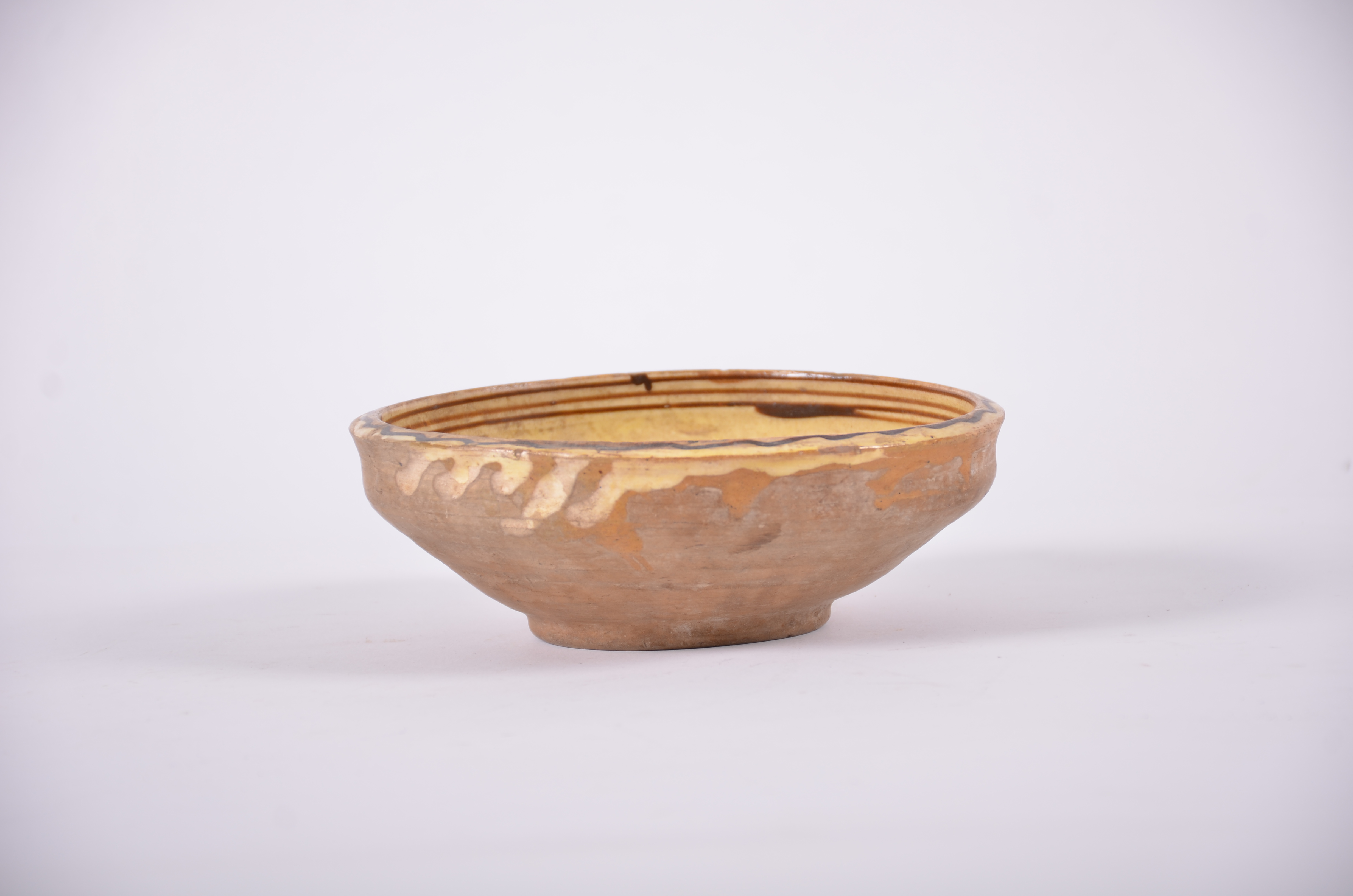 Vasul ceramic este de formă tronconică, cu baza înălțată și gura dreaptă. Piesa este decorată prin stropire cu pete neregulate și cu motive geometrice (cercuri concentrice). Este smălțuit în interior. Buza vasului prezintă motiv geometric (valul). Cromatică: fond: alb; motive: maro; verde; cărămiziu.