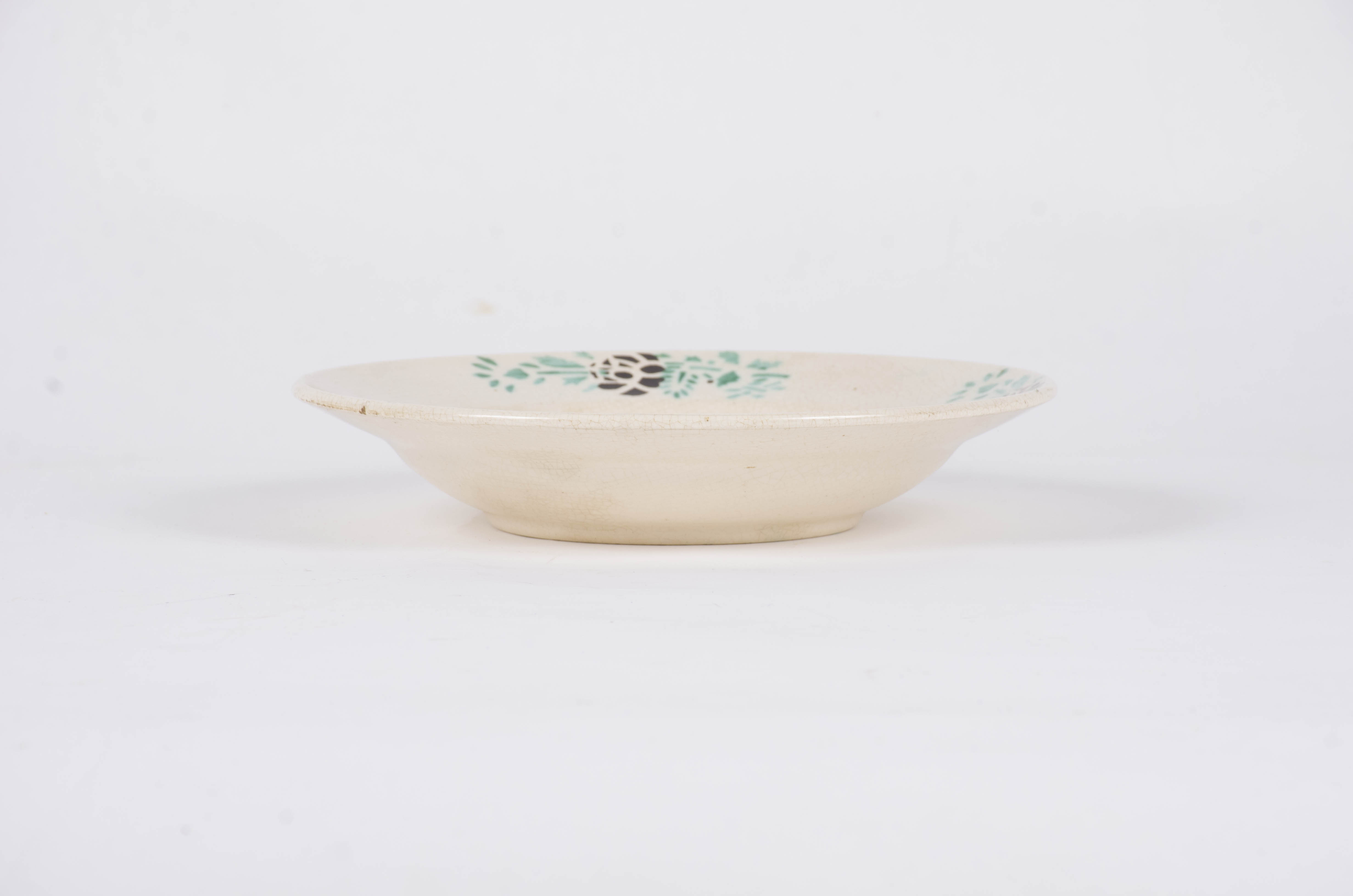Vasul ceramic este de formă tronconică fiind decorată cu motive florale dispuse central sub forma unui buchet de flori, iar pe marginea farfuriei sunt dispuse într-un registru circular motive floral-vegetale pe un fond alb. Farfuria este smălțuită. Cromatică: fond: alb; motive: verde; maro.