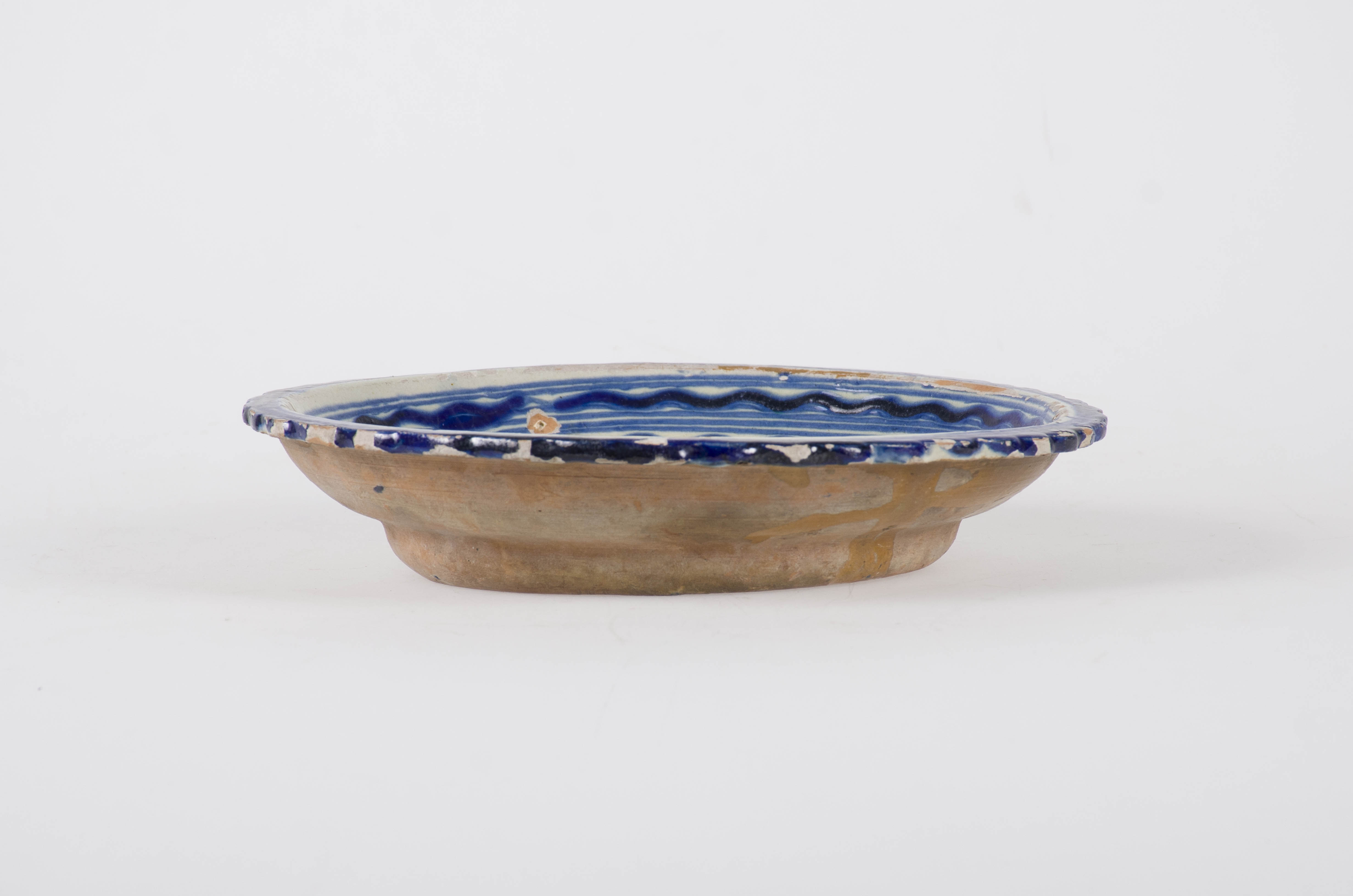 Vas ceramic smălțuit de formă tronconică, cu pereții evazați și marginea zimțată trasă orizontal spre exterior. Marginea este de culoare albastră. Pe perete sunt prezente cercuri concentrice și două cercuri ondulate. Central, sub un cerc dublu este realizat un buchet floral. Exteriorul este prevăzut cu o ureche pentru agățat, fiind nesmălțuit. Cromatică: fond alb interior; fond cărămiziu exterior; ornament albastru.