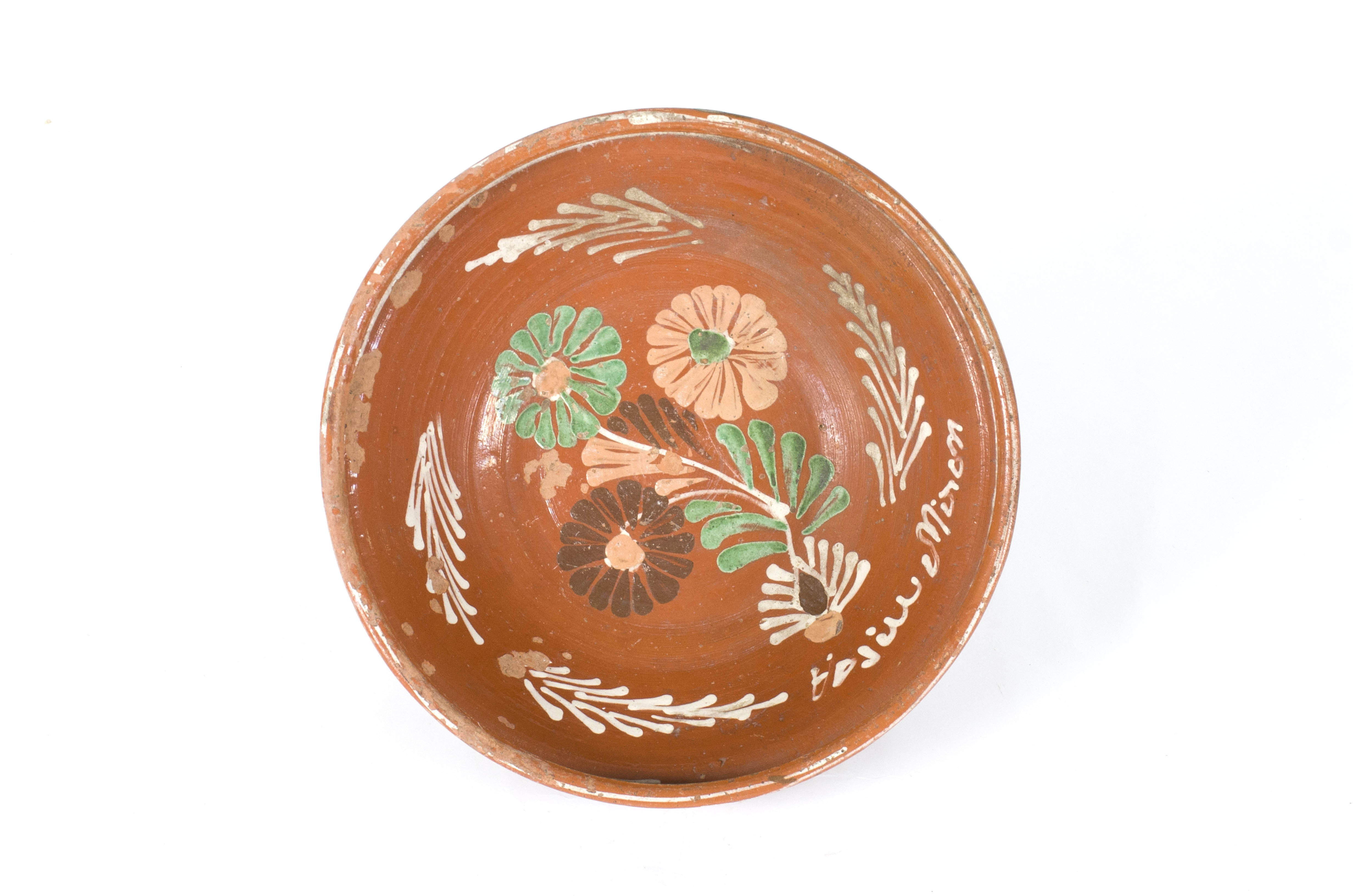 Vas ceramic de formă circulară și profil tronconic, cu buza înălțată și ieșită înafară. Este smălțuită la interior și exterior în zona buzei. Este decorat în interior cu motive florale și vegetale (trei flori, una cu petale verzi, una cu petale maro închis și una crem și frunze în aceleași culori). Pe pereții vasului sunt patru motive fitomorfe stilizate între care se regăsște și numele Vasiu Miron. Buza vasului este ornamentată cu cercuri concentrice și o linie în val. Cromatică: fond: cărămiziu; maro; motive: alb; verde; maro; crem.