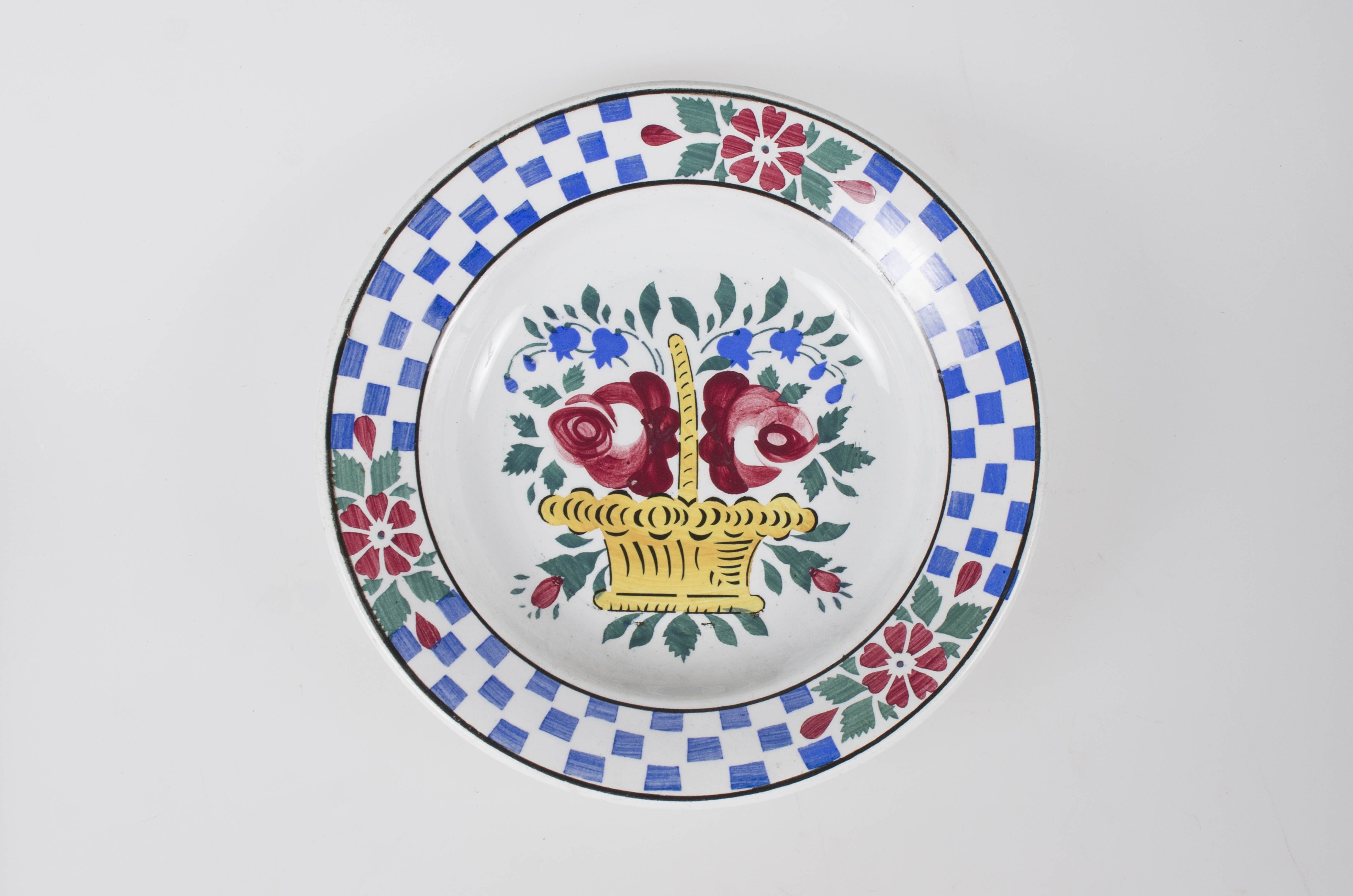 Vas de formă tronconică, adâncă. Pe fundul farfuriei se află un ornament format din: un coș de flori (trandafiri și clopoței). Pe marginea farfuriei între două cercuri concentrice apar trei flori despărțite de trei registre în formă de tablă de șah realizate din dreptunghiuri albastre. Cromatică: fond: alb; motive: galben; roșu; verde; albastru; negru.