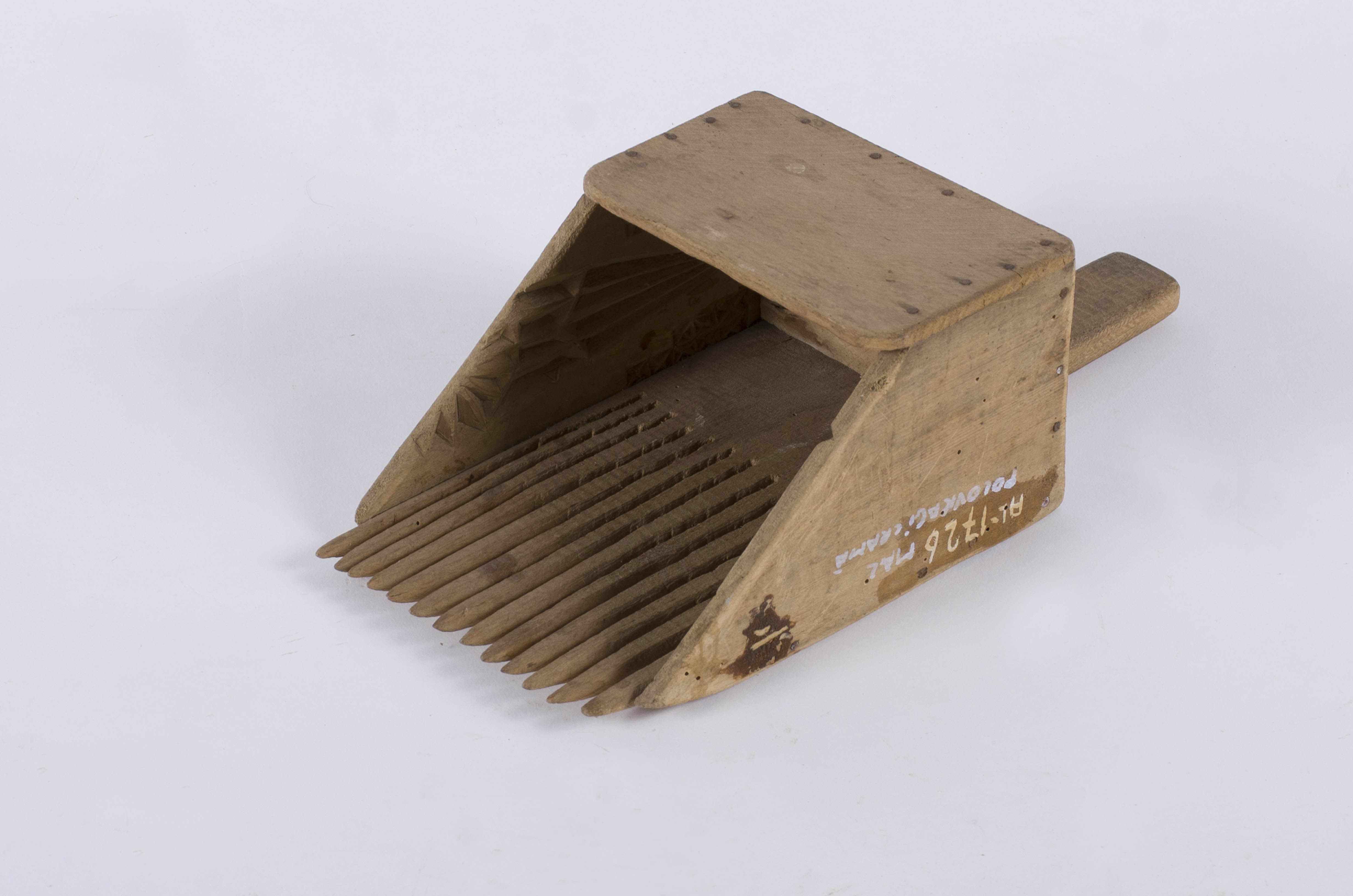 Pieptene pentru afine format dintr-o cutie trapezoidală realizată din scânduri subțiri din lemn de fag și tei, asamblate cu ajutorul cuielor metalice. Prezintă mâner în partea dinapoi. Marginile cutiei sunt inegale, una dintre ele fiind prelungită și tăiată, formând astfel cei 13 dinti. Părțile laterale ale cutiei colectatoare de afine prezintă pe interior ornamente geometrice și florale stilizate: o semirozetă și două rânduri de cruci în X pe ambele părți. Uzură funcțională. Cromatică: culoarea patinată a lemnului.