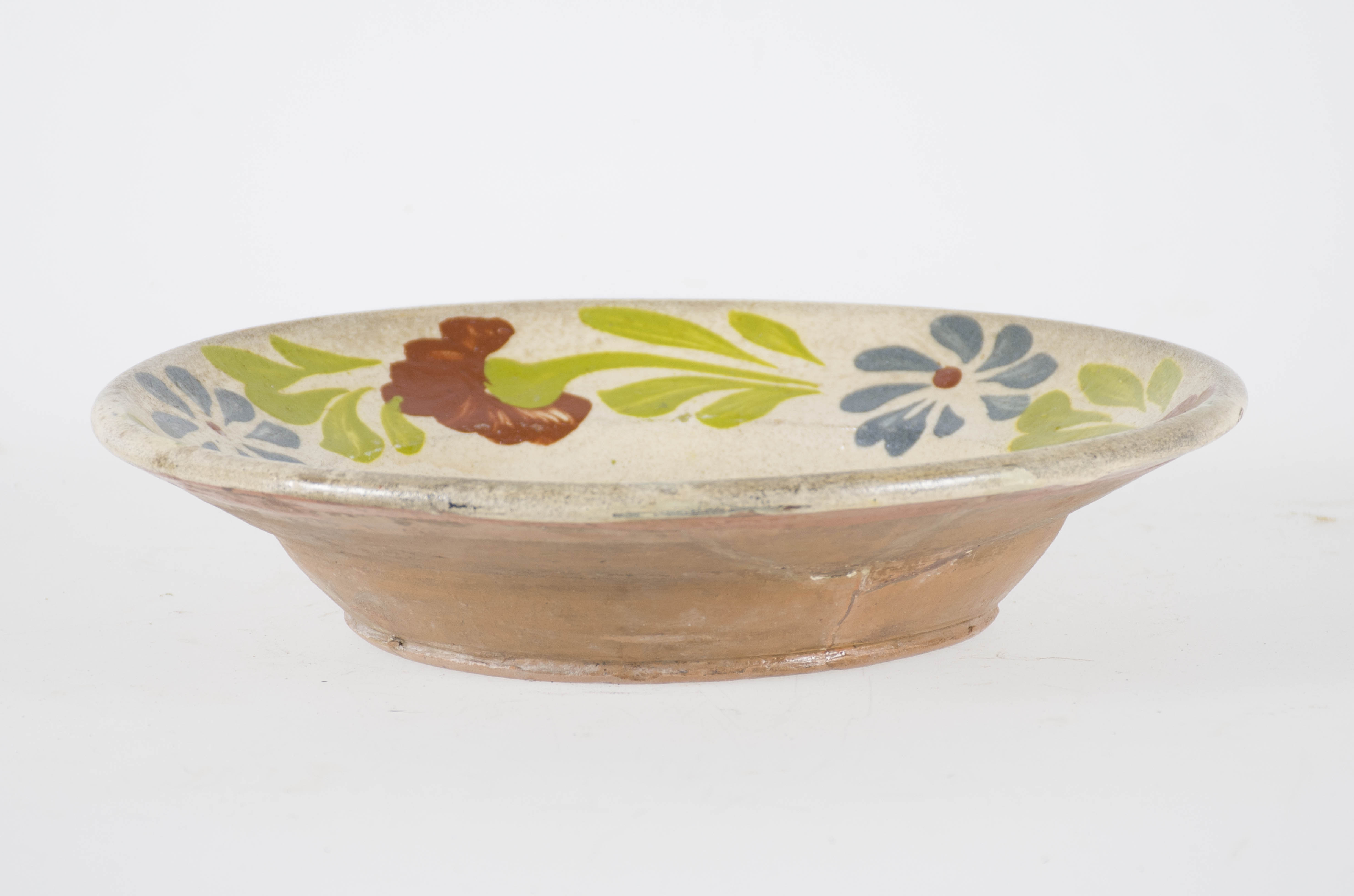 Vasul ceramic de formă tronconică prezintă pereții curbați și marginea evazată. Este smălțuit numai în interior. Este decorat în centru cu motive florale și fitomorfe: 3 flori și frunze; pe margine chenar floral realizat din 3 flori albastre și 3 flori maro despărțite de frunze. Cromatică: fond: alb; motive: brun; verde; albastru.