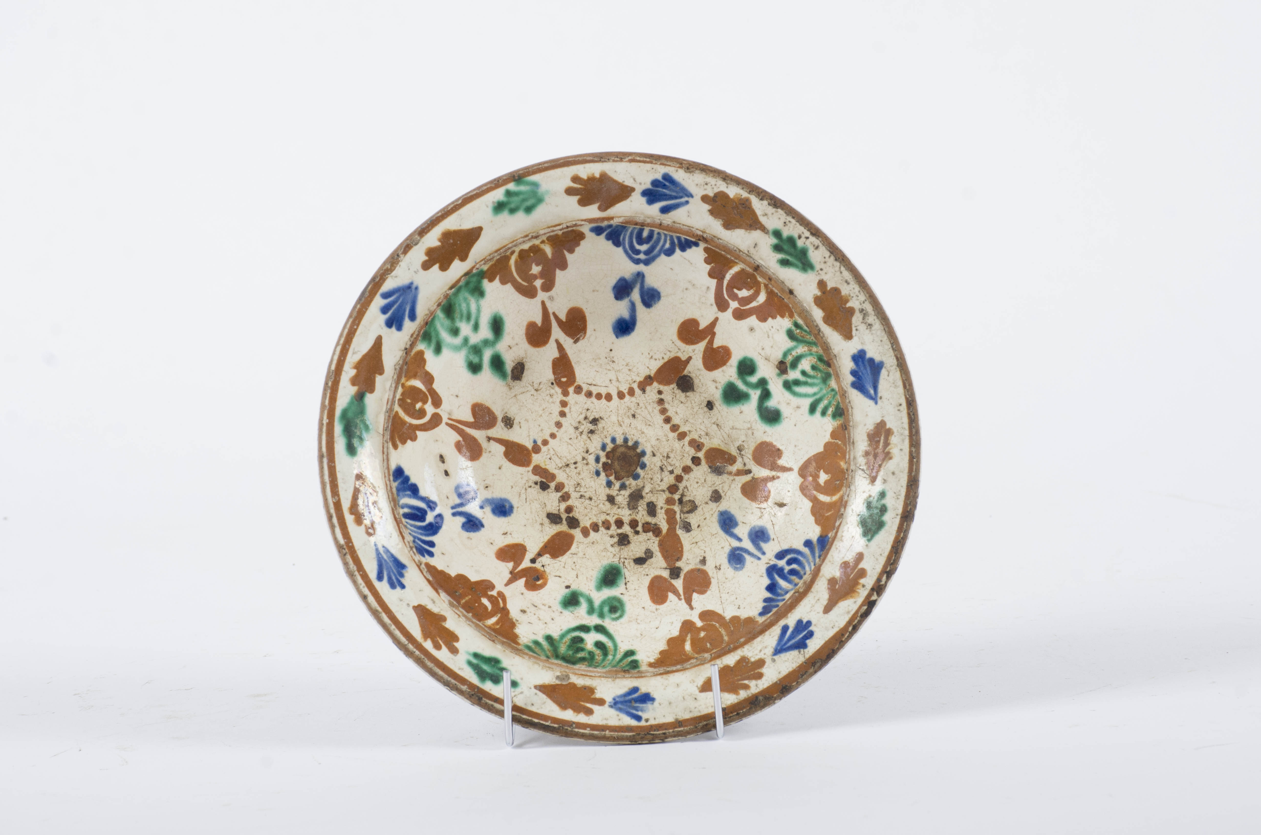 Vasul ceramic este de formă circulară cu pereții evazați și fundul aplatizat. Decorul este amplasat pe întreaga suprafață cu motive vegetale (frunze în zona buzei) și motive florale stilizate ce coboară de sub buză pe partea superioară a corpului și motive geometrice punctiforme ce descriu o stea plasată central. Cromatică: fond: alb-crem; motive: maro; verde; albastru.