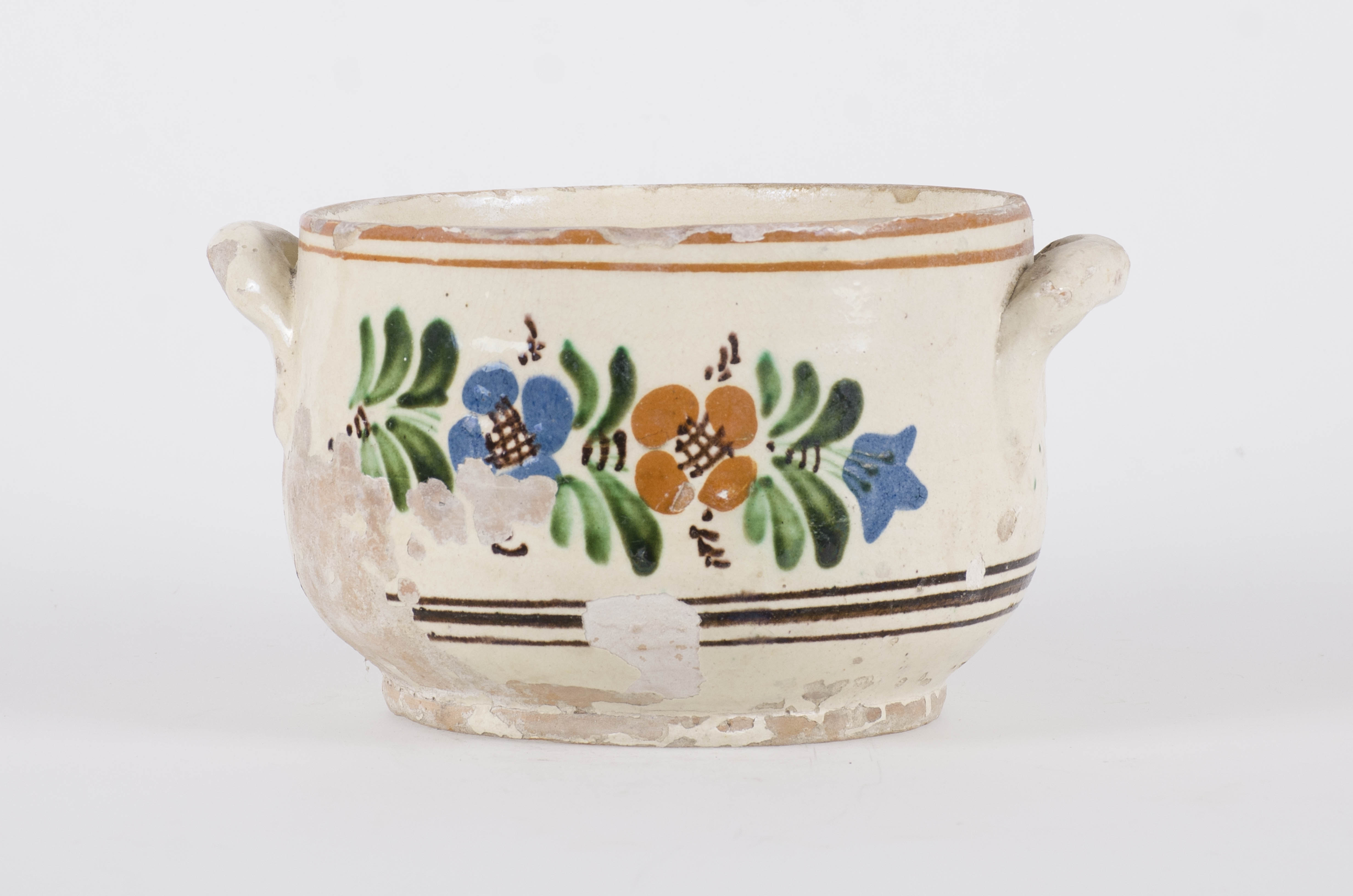 Vasul ceramic are formă cilindrică, îngustată la gât, care permite fixarea capacului. Două "tortițe" laterale dispuse oblic permit purtarea castronului. Motivul ornamental principal este constituit dintr-un câmp floral. Pe fondul alb-gălbui al ornamentului, la buză și la baza vasului se află cercuri concentrice. Cromatică: fond: crem; motive: verde; maro; albastru; roșu-cărămiziu.
