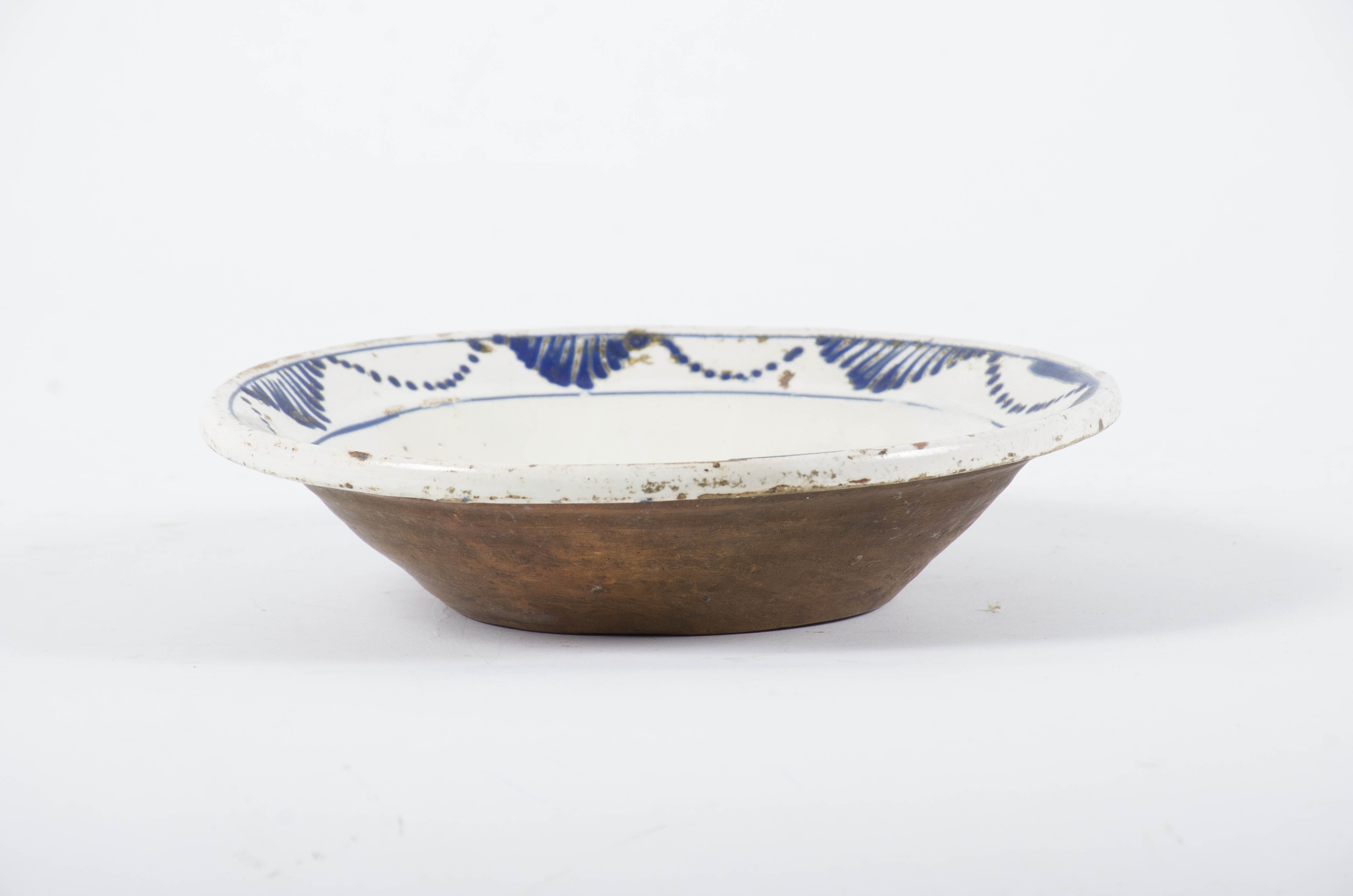 Blidul ceramic este rotund, adânc, cu pereții evazați și cu buza răsfrântă înafară. Fața este smălțuită și ornamentată. Centrul blidului este marcat de o rozetă. Între cele două cercuri ce marchează buza vasului se găsește un ornament geometrizant (arcuri de cerc punctate și triunghiuri hașurate). Cromatică: fond: alb; motive: albastru.