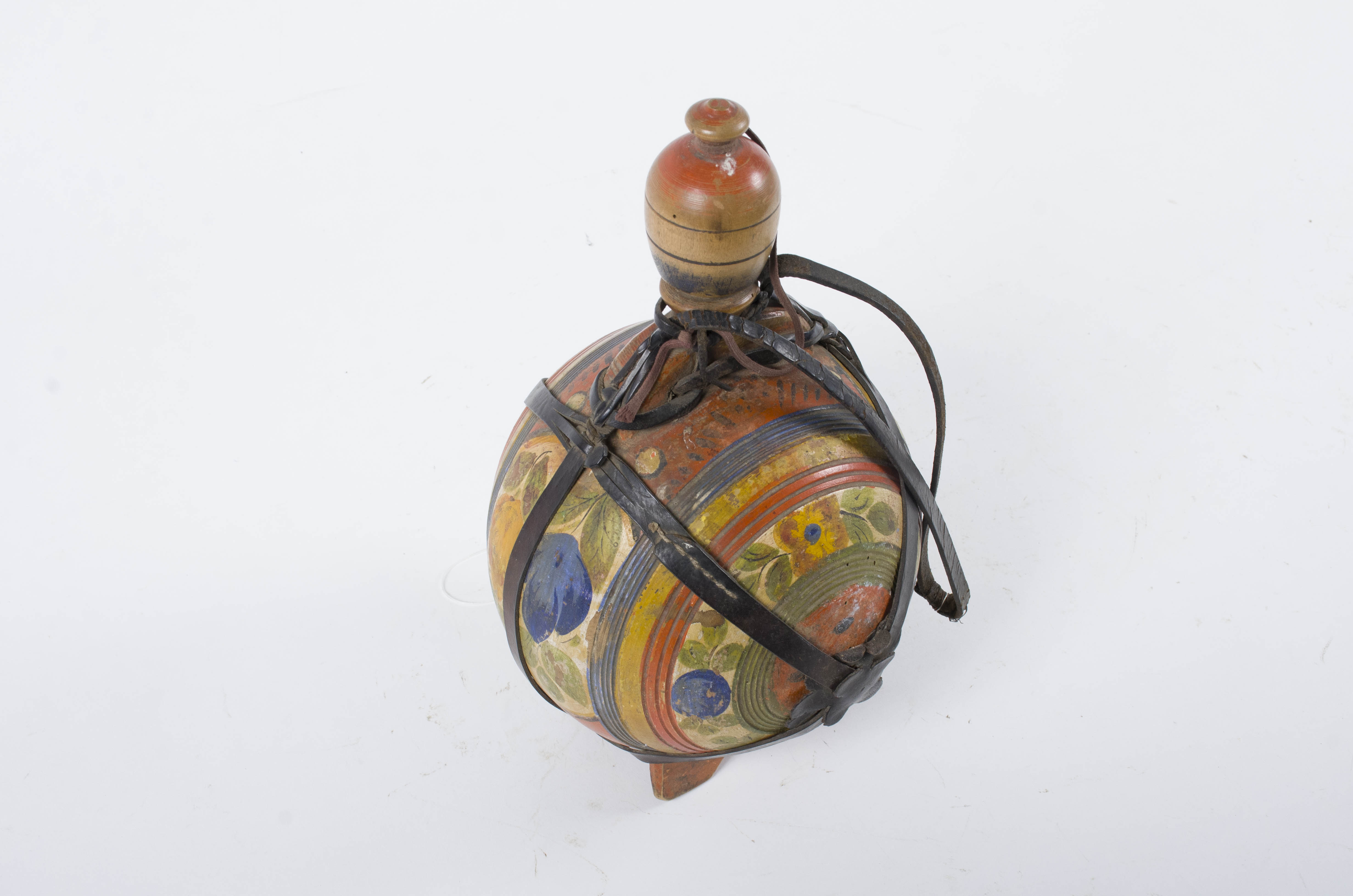 Recipientul din lemn este globular și este prevăzut cu patru picioare și cu un umăr cu două orificii. Prezintă un gât îngust, un dop-capac și o baieră din piele decorată. Plosca este decorată pe toata suprafața cu ornamente în registre (organizare radială): decor geometrizant; motive geometrice propriu-zise (cercul; rozeta); decor naturalist: motive florale. Cromatică: roșu; galben; albastru; negru; verde; oranj.