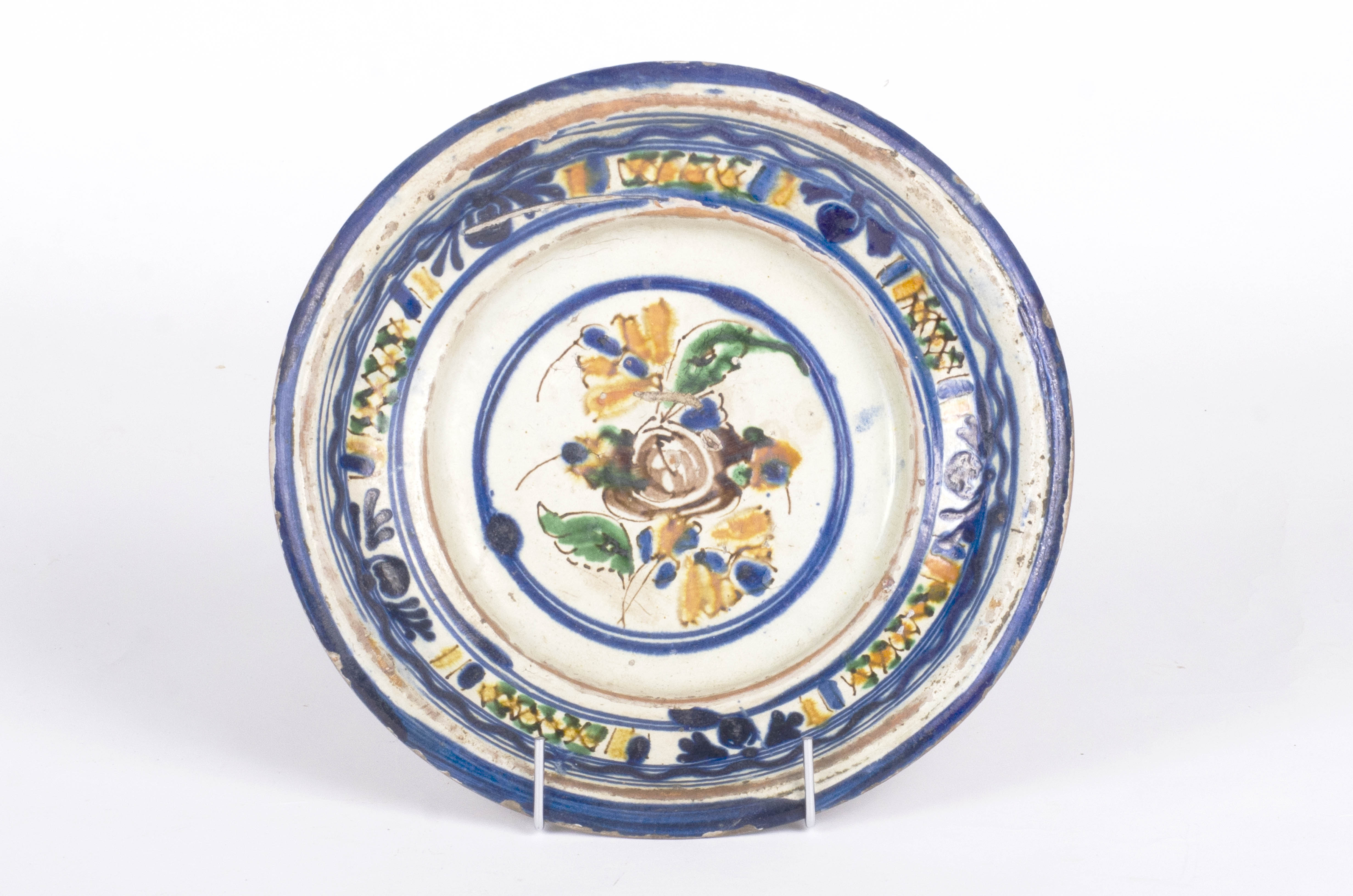 Vasul ceramic este de formă circulară, ușor adâncit, cu pereți evazați și ondulați. Decorul este amplasat pe două registre: primul registru se găsește la partea inferioară a buzei și se înscrie perimetral pe aceasta cu motive geometrice și florale (cercuri), al doilea registru este plasat central pe fundul vasului și prezintă același tip de motive. Cromatică: fond: alb-crem; motive: albastru; galben; verde; maro.