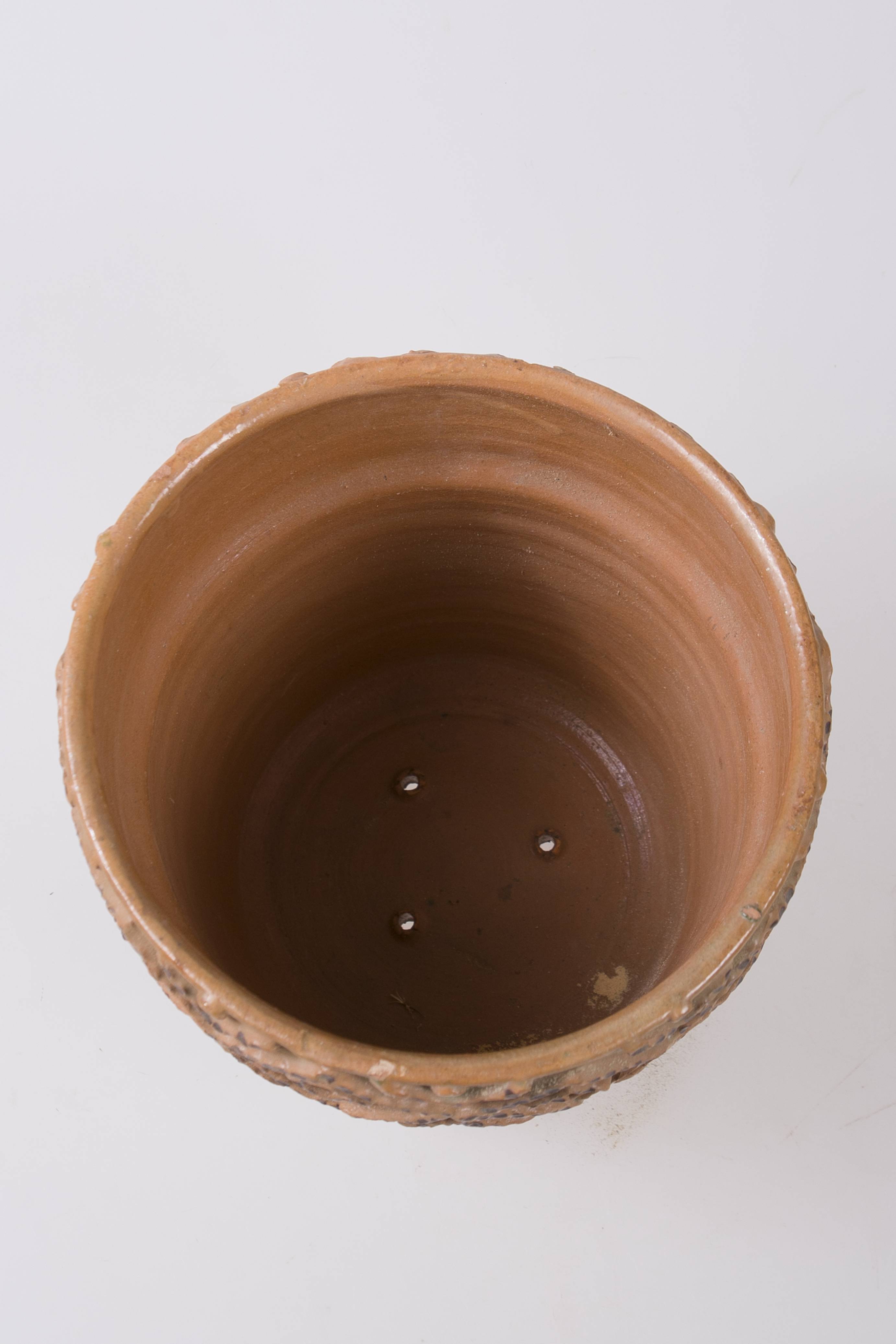 Vas ceramic de formă tronconică cu baza mai îngustă, manșon sub gura lată de 6,2 cm. Ornamentat cu un lanț de romburi înscrise și unghiuri din brâie alveolate umplute cu vopsea aplicată cu cornul și fund perforat.