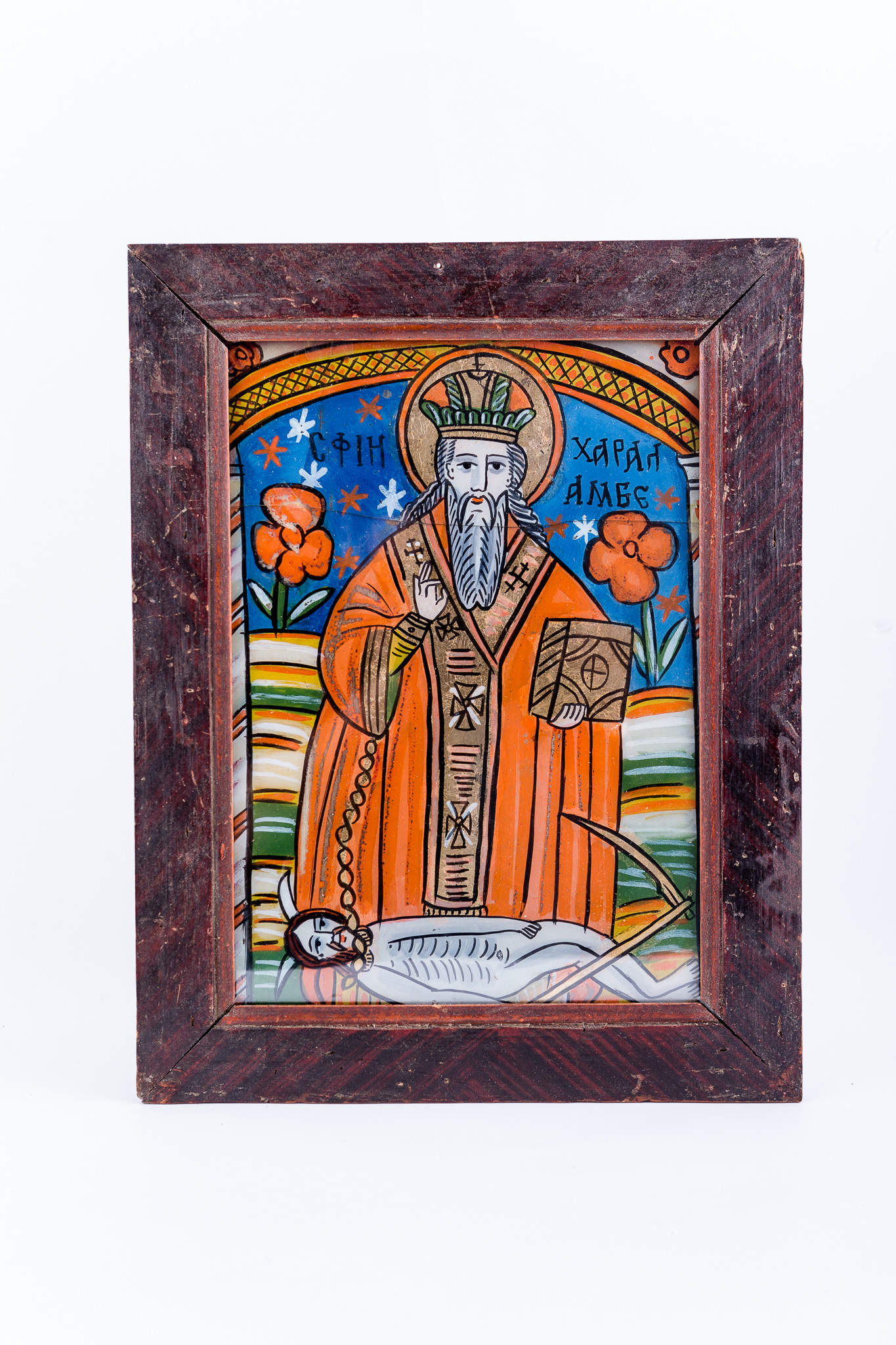 Sfântul Mare Mucenic Haralambie, făcător-de-minuni, este cel mai bătrân mucenic din cei prăznuiți de creștini. Este cunoscut ca și făcător-de-minuni, vindecător de boli și ocrotitor al caselor familiilor creștine. Central este pictat Sfântul, îmbrăcat cu veșminte liturgice, arhierești, cu sacos roșu vermillon și epitrahil brun, cu patru cruci, cu mithră și aureolă. Fiind foarte bătrân, are barbă albă, lungă. În mâna stângă are Sfânta Evanghelie închisă și cu mâna dreaptă ține în lanț ciuma, reprezentată antropomorfic, și binecuvântează. Ciuma, simbolizând boala incurabilă și moartea, are trup omenesc gol, cu secera în mână și coarne de diavol, fiind, totodată și păcatul, patima, aducătoare de moartea duhovnicească. Fondul este albastru bleu-ciel cu steluțe albe și roșii, registrul superior, și câmpuri alternative de galben, alb și verde, în registrul inferior. În registrul îndepărtat, stânga și dreapta sfântului ierarh, este câte o floare uriașă roșie, reprezentând martori și ucenici ai sfântului. Silueta Sfântului este încadrată de o boltă de biserică, asemenea unui curcubeu de nădejde, care reliefează și mai mult chipul luminos al faptelor minunate și vindecătoare. Cromatica armonioasă: roșu vermillon, verde, albastru, galben-ocru, alb, negru se întrepătrunde estetic cu detaliile minuțioase ale desenului. Icoana se înscrie în Șcheii Brașovului din Țara Oltului. Inscripția în chirilică se traduce Sf Haralambie.