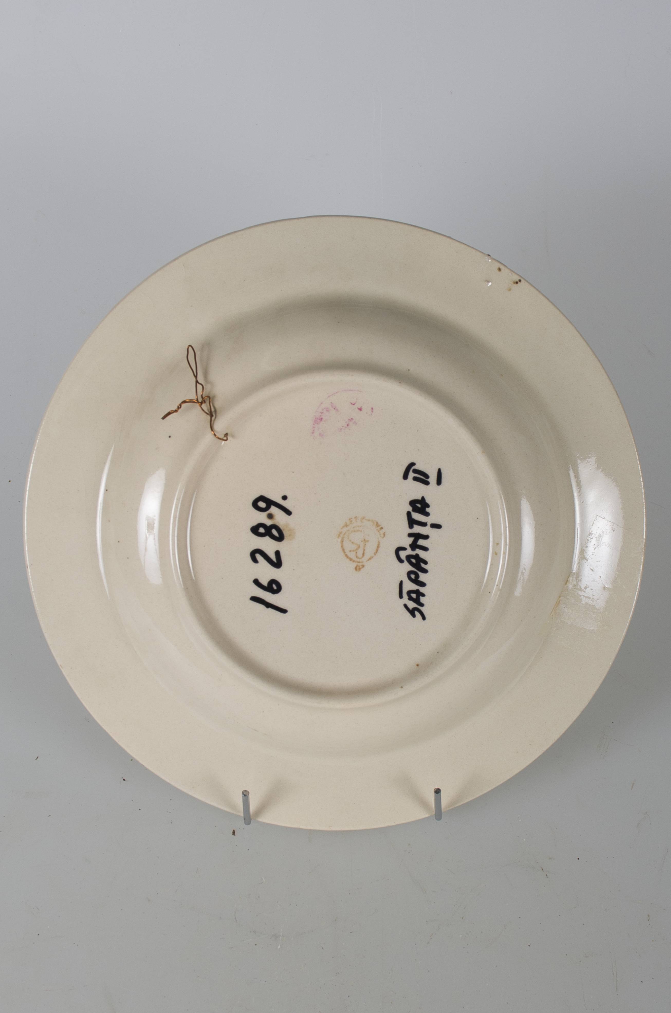 Vas ceramic smălțuit de formă tronconică, cu marginile puțin ridicate și fundul plat. Decorat prin pictare pe fund cu trei trandafiri roșii cu tulpină și frunze verzi, și patru boboci, pe margine are bandă galbenă încadrată între două linii concentrice maro; șase boboci dispuși între șase crengi cu frunze. Cromatică: fond: alb; crem; motive: roșu; verde; galben; maro.