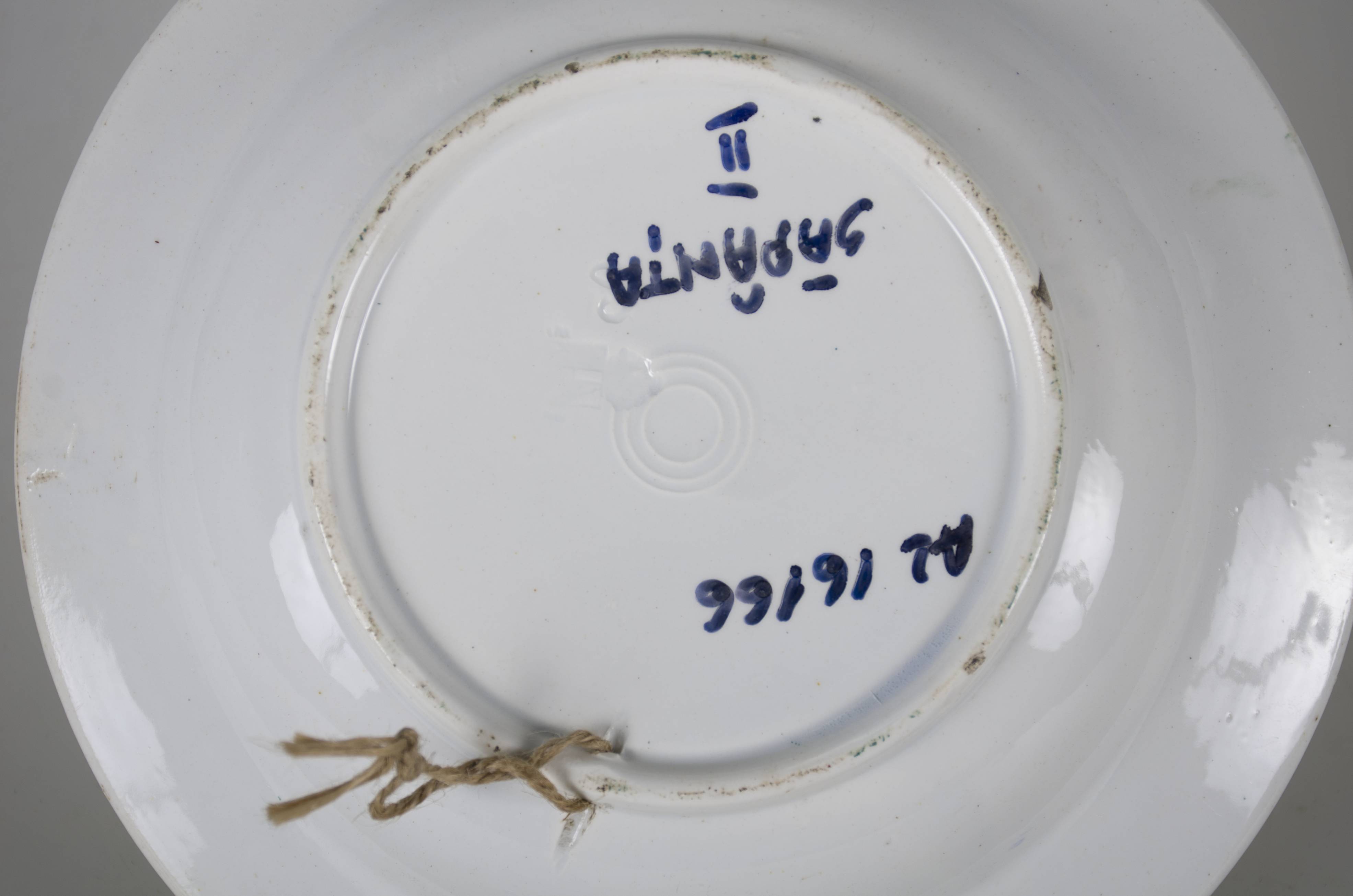 Vas ceramic smălțuit, de formă tronconică, cu marginile puțin ridicate și fundul plat. Pe fond alb decorații ilustrând o compoziție ce are în centru un trandafir roșu, la bază sunt două flori albastre. Compoziția, aflată pe fundul vasului, completată cu frunze verzi și doi boboci de floare roșii. Pe marginile vasului sunt pictate 12 flori roșii, dispuse în patru grupe de câte două și patru plasate individual, despărțite de frunze verzi. Pereții interiori sunt conturați de două linii albastre dispuse circular.