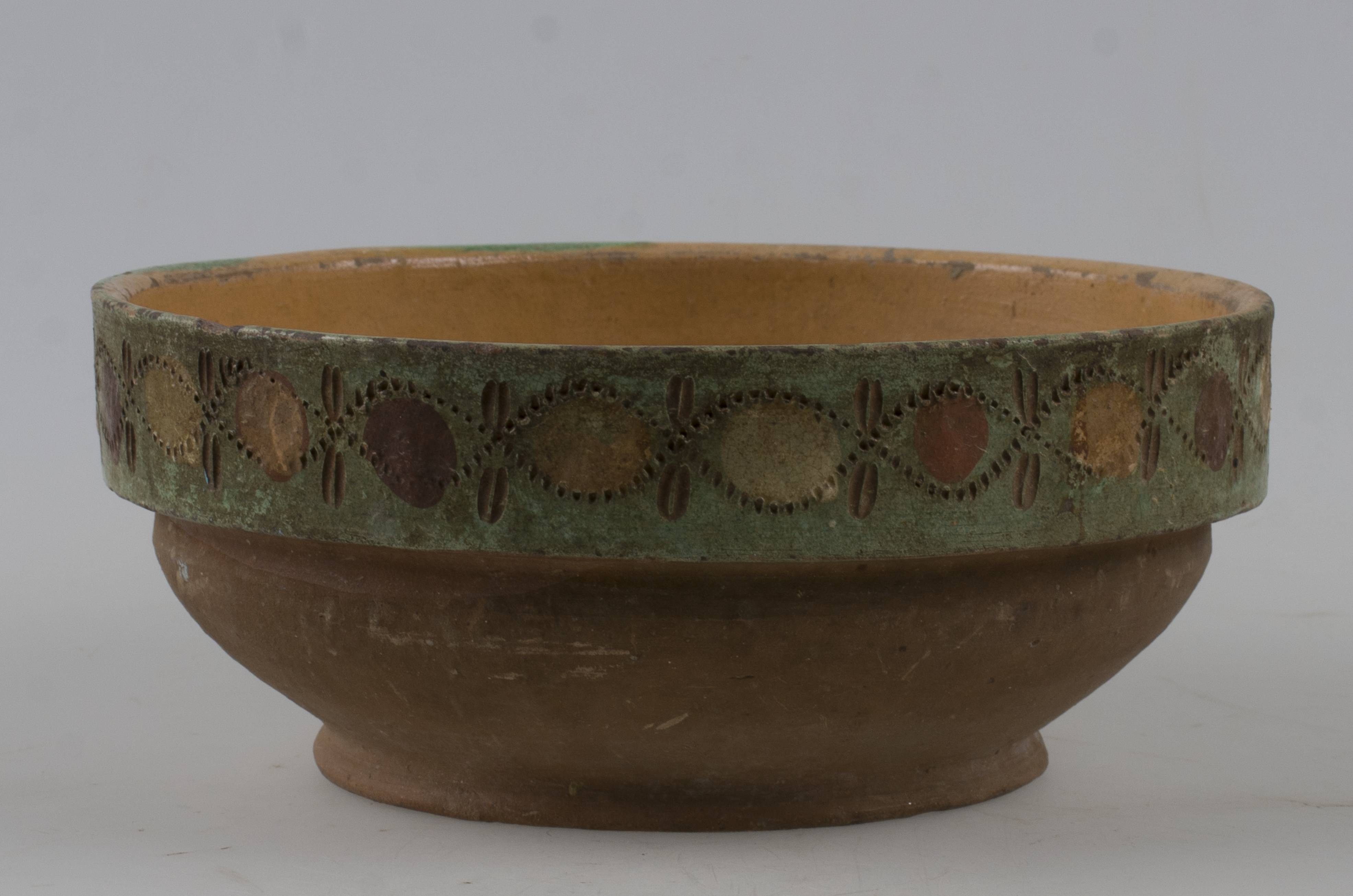 Vas ceramic de formă tronconică cu picior de susținere pronunțat, cu pereți puțin bombati pornind din fundul vasului și buza dreapta. Decorul este prezent pe fund (floare pictată pe fund încadrată de patru linii concentrice drepte și pe exteriorul buzei (spirale din linii curbe punctate, intrepătrunse și ”ochi”). Cromatică: fond: cărămiziu; motive: verde; maron; crem.