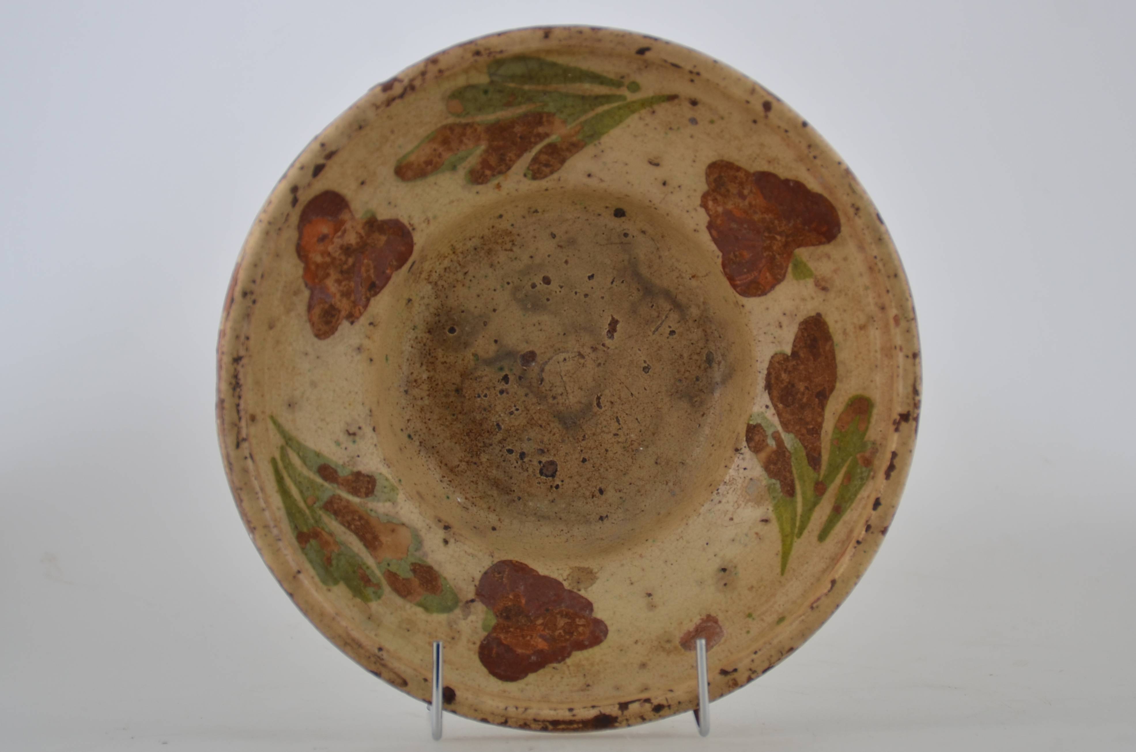 Vas ceramic de dimensiuni reduse, prezintă baza plată, pereții evazați, gura înaltă și arcuită spre interior cu buza ușor evazată. Vasul este smălțuit în interior și în exterior (doar buza). Decorul este dispus pe pereții evazați ai vasului, peste stratul crem de angobă, constând în trei flori roșii cu frunze verzi. Cromatică: fond: crem; motive: roșu; verde. Prezintă uzură funcțională.