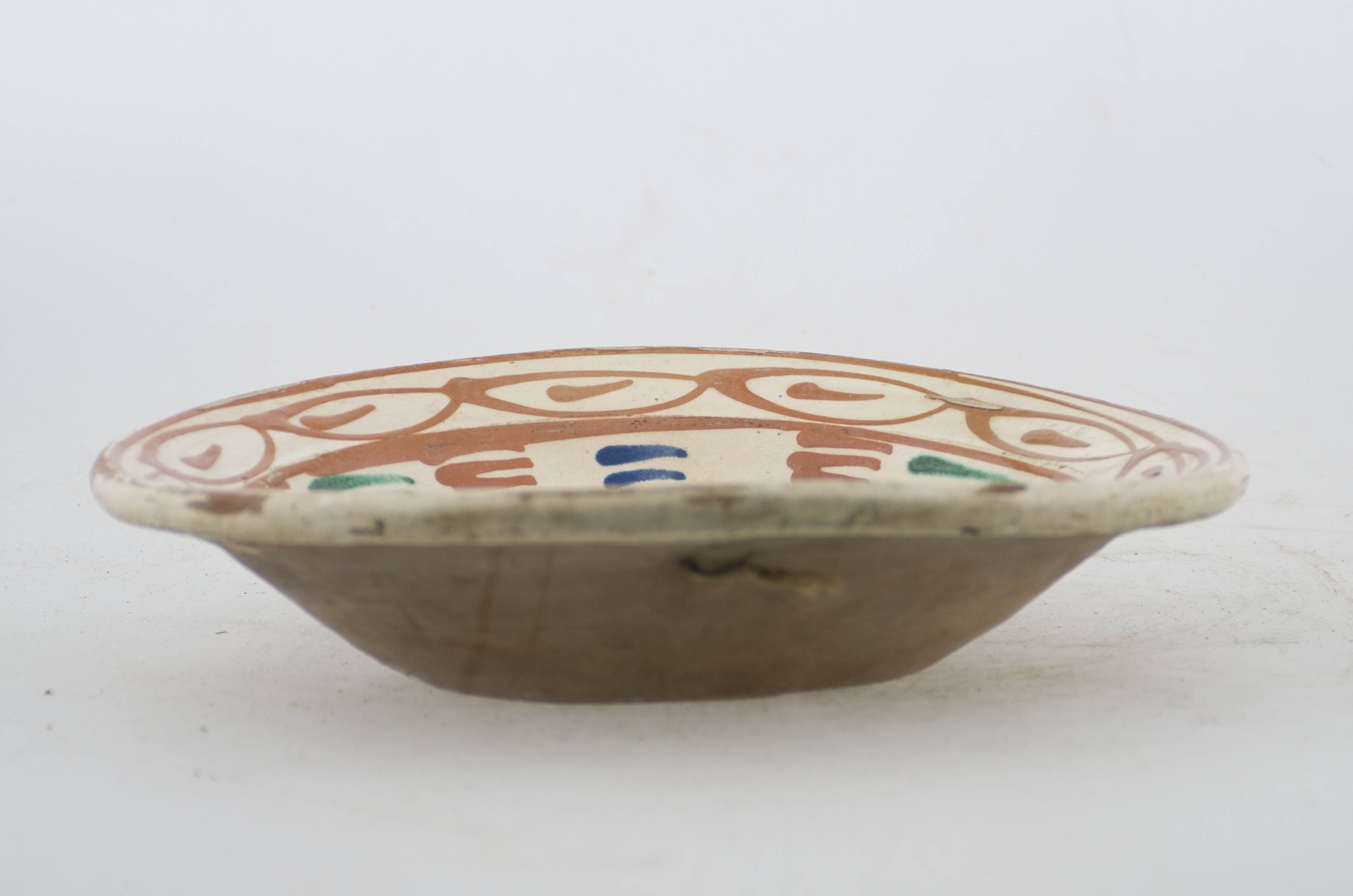 Vas ceramic de formă tronconică cu baza plată, pereții larg evazați și buza profilată. După modelarea la roată, uscarea și arderea recipientului, a fost aplicat un strat de angobă în interiorul vasului, peste care a fost pictat decorul floral și vegetal stilizat, format din două registre. Primul registru, situat pe fundul și pereții vasului, și încadrat de o linie circulară, a fost decorat cu motice florale stilizate: o floare cu patru petale, între care au fost încadrate patru grupuri a câte patru stamine. Pereții vasului au fost și ei decorați cu motive vegetale stilizate: paisprezece „brăduți”, dispuși circular. Al doilea registru, cel care decorează buza recipientului ceramic și este mărginit, la rândul lui de o linie circulară, prezintă un brâu compus din elemente geometrice (ovaluri unite între ele, cu linie orizontală neregulată, înscrisă central). Cromatică: fond: crem la interior; cărămiziu la exterior; motive: verde; galben-muștar.