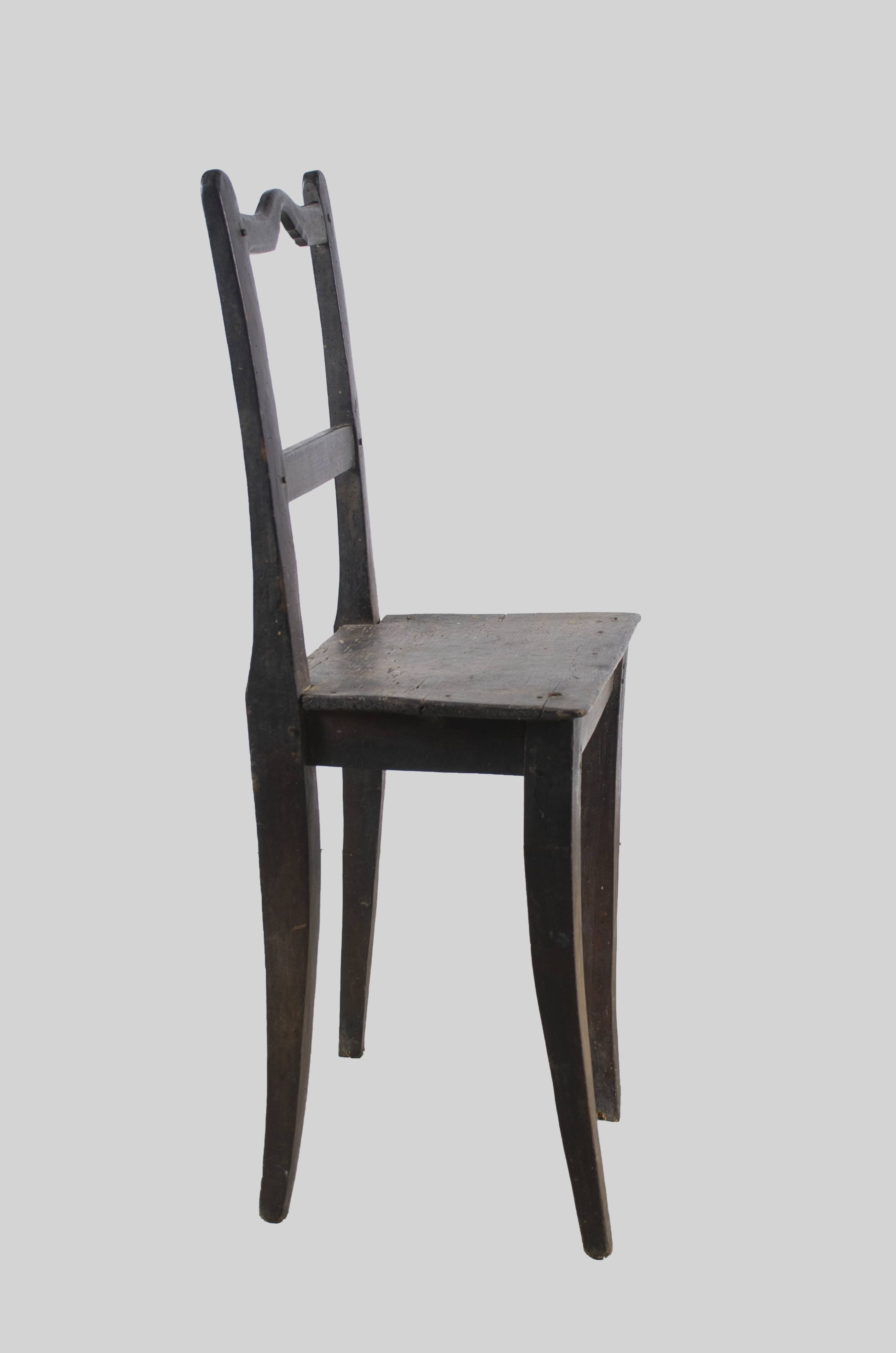 Mobilier din lemn, având șezutul de formă trapezoidală, sprijinându-se pe patru picioare, dintre care două formează și spătarul, fiind alungite. La îmbinarea cu șezutul, picioarele sunt întărite cu câte patru scândurele. Picioarele din spate sunt unite între ele cu două elemente din lemn: una în partea mediană care este dreaptă și una în partea superioară care prezintă o curbură la mijloc. Picioarele sunt evazate. Cromatică: culoarea lăcuită a lemnului.