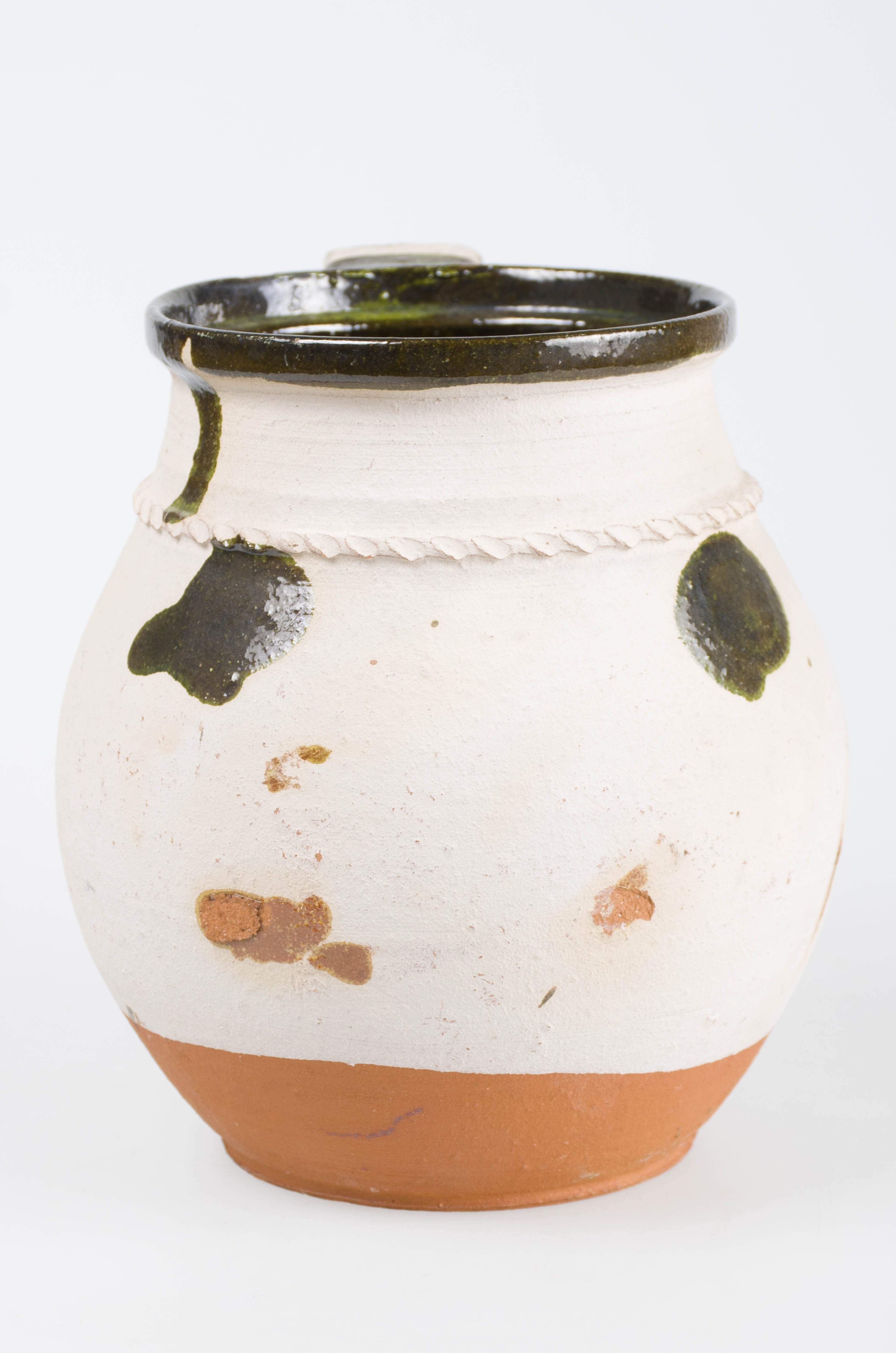 Vas ceramic piriform, cu gât îngust și buza ușor răsfrântă. Acesta este prevăzut cu o toartă lată ce prezintă pe margini amprente digitale făcute în lutul moale. Toarta pornește din buză și se unește cu corpul la diametrul maxim. Este angobat pe 90 % din suprafața exterioară a vasului și smălțuit la gură și pe corp, sub formă de spirale și 8-uri. În partea superioară, în zona gâtului, a fost aplicat un brâu alveolar. Cromatică: cărămiziu la interior, alb și cărămiziu la exterior; motive: verde.
