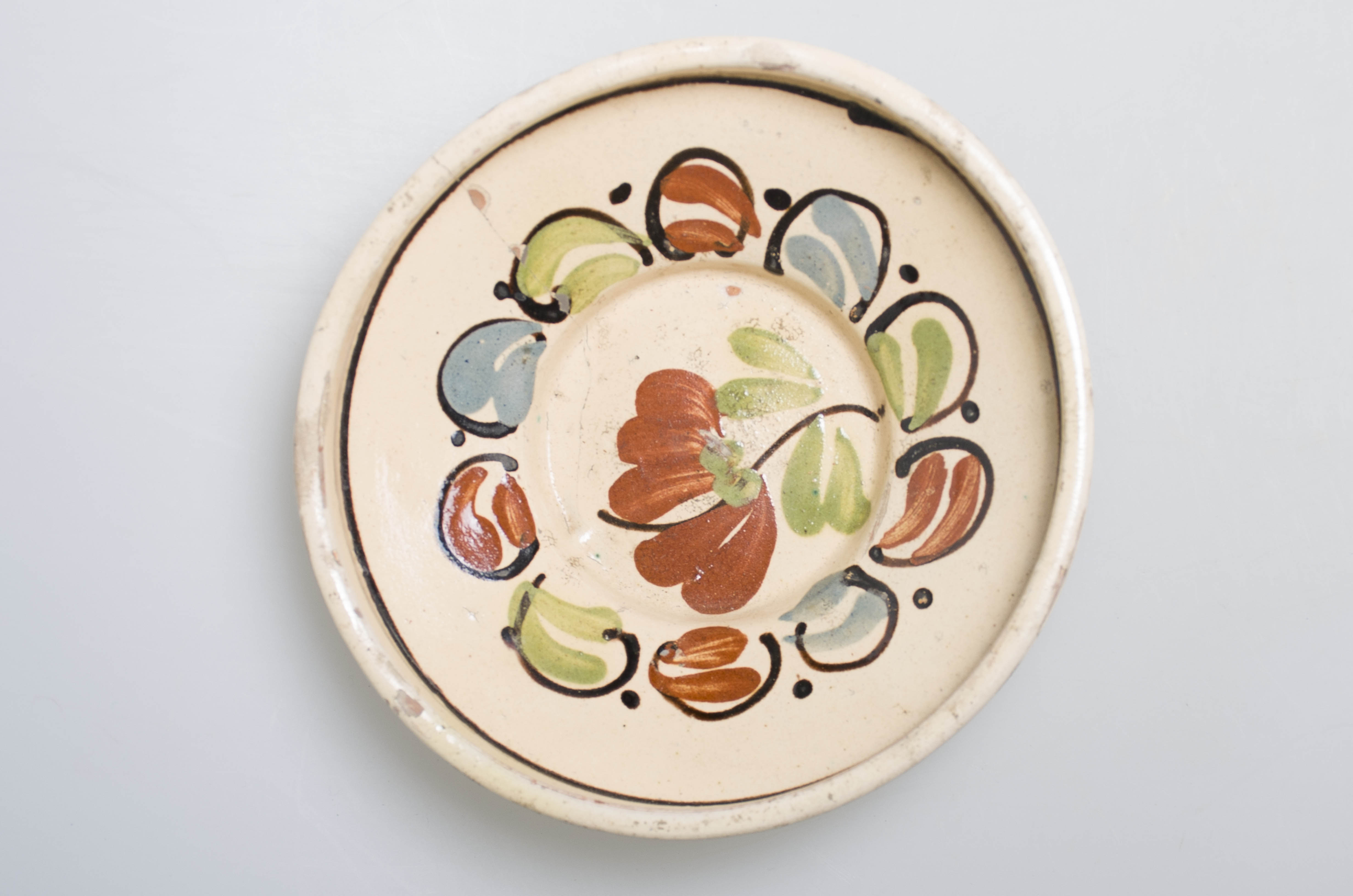 Blid tronconic, realizat din ceramică, are gura largă, înaltă și dreaptă, fiind smălțuit integral în partea interioară și în exterior doar la nivelul buzei. Decorul din interior este unul vegetal și liniar, iar la exterior prezintă o linie vălurită, fiind executat cu pensula. Fundul este circular și prezintă un orificiu pentru agățare. Cromatică: fondul: crem; decor: verde; albastru; negru; maro.