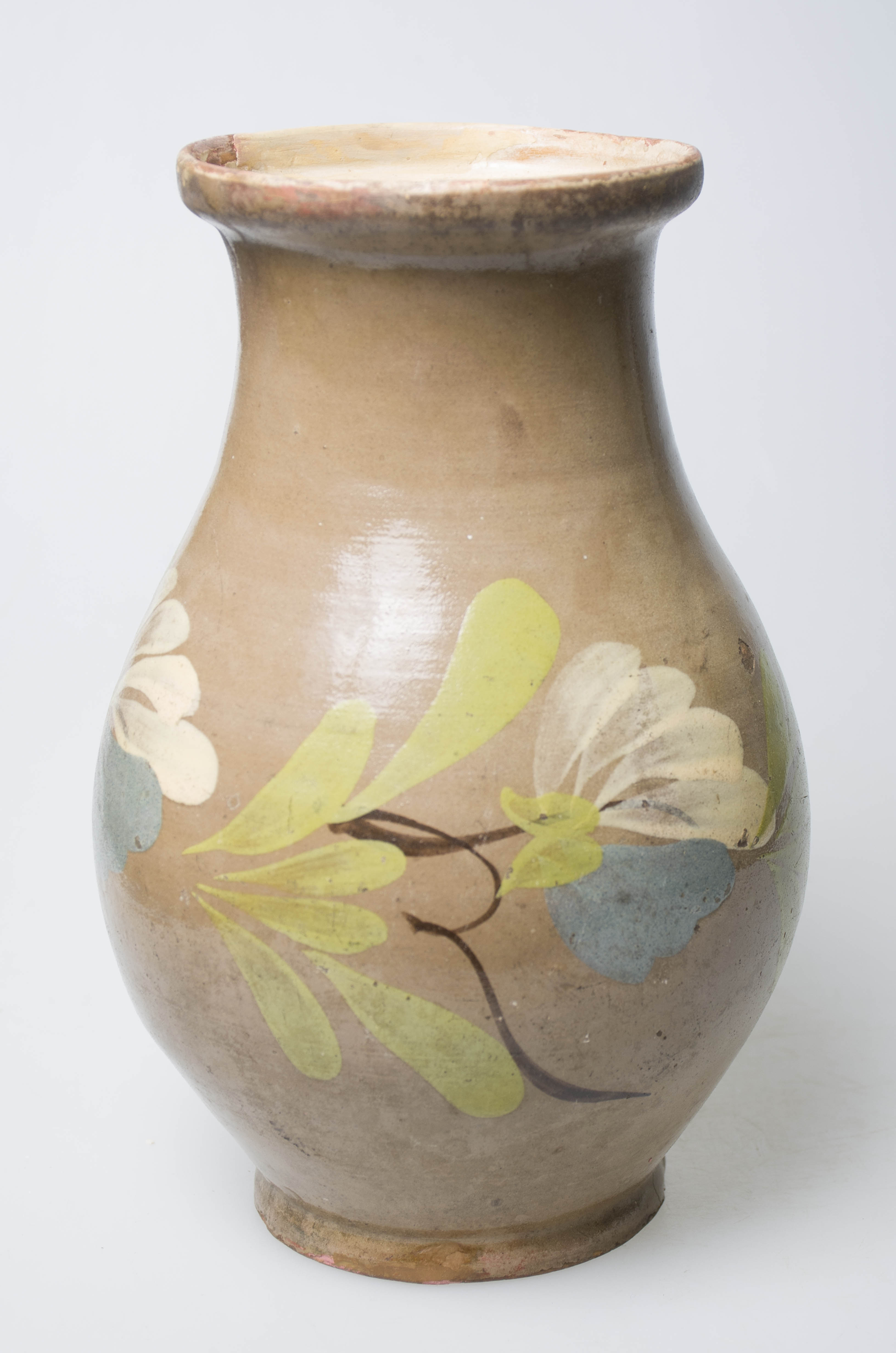 Vas ceramic de formă bitronconică cu buza evazată. Prezintă o toartă ce pleacă din zona gâtului și se leagă pe diametrul maxim al corpului. Smălțuită atât la interior cât și la exterior. Decorul este format din motive vegetale și florale, plasate pe corp, în jumătatea inferioară a vasului. Cromatică: fond: crem; motive: verde; alb; albastru.