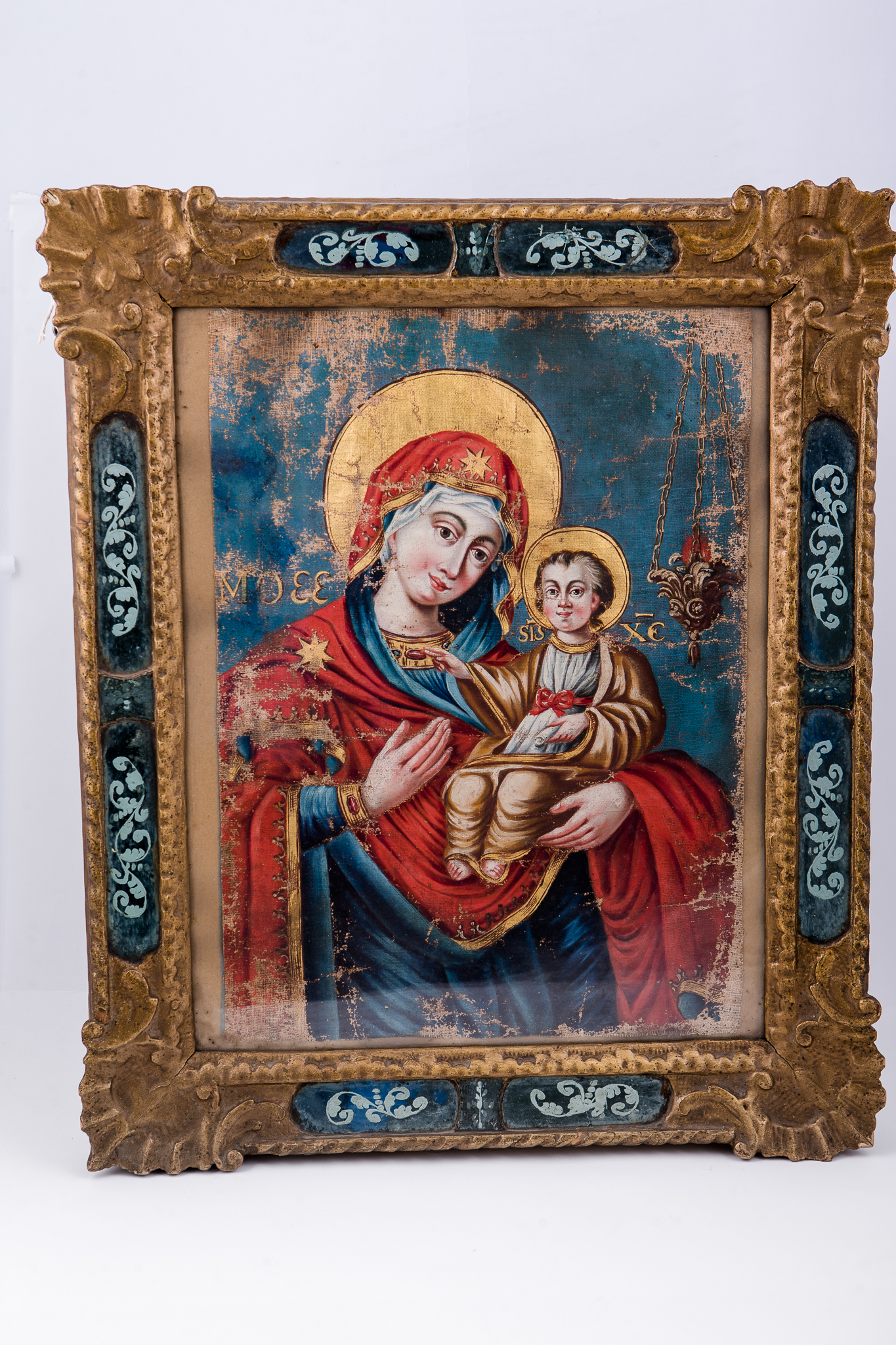 Maica Domnului ține în brațe Pruncul Iisus Hristos, care arată cu mâna dreaptă înspre Maica Domnului, prezentându-ne-o. Maica Domnului este înveșmântată în mantie cu maforion roșu-stacojiu, cu interiorul albastru bleu-ciel. Maica Domnului are aureola galbenă. Pruncul Iisus Hristos este înveșmântat cu sacos și omofor galben-ocru, cu coroană și aureolă pe cap. Fondul icoanei este albastru ceruleum. În stânga Maicii Domnului este o candelă atârnată, în dreptul Pruncului Iisus Hristos, Lumina lumii. Cromatica este armonioasă: roșu, albastru bleu-ciel, galben, ocru, brun, acajou, brun-ocru, brun, bej, negru. Icoana este pictată în manieră barocă și are atmosfera catolică. Rama este bronzie, cu elemente decorative florale aurii, sculpturale în basorelief, decorațiuni baroce.