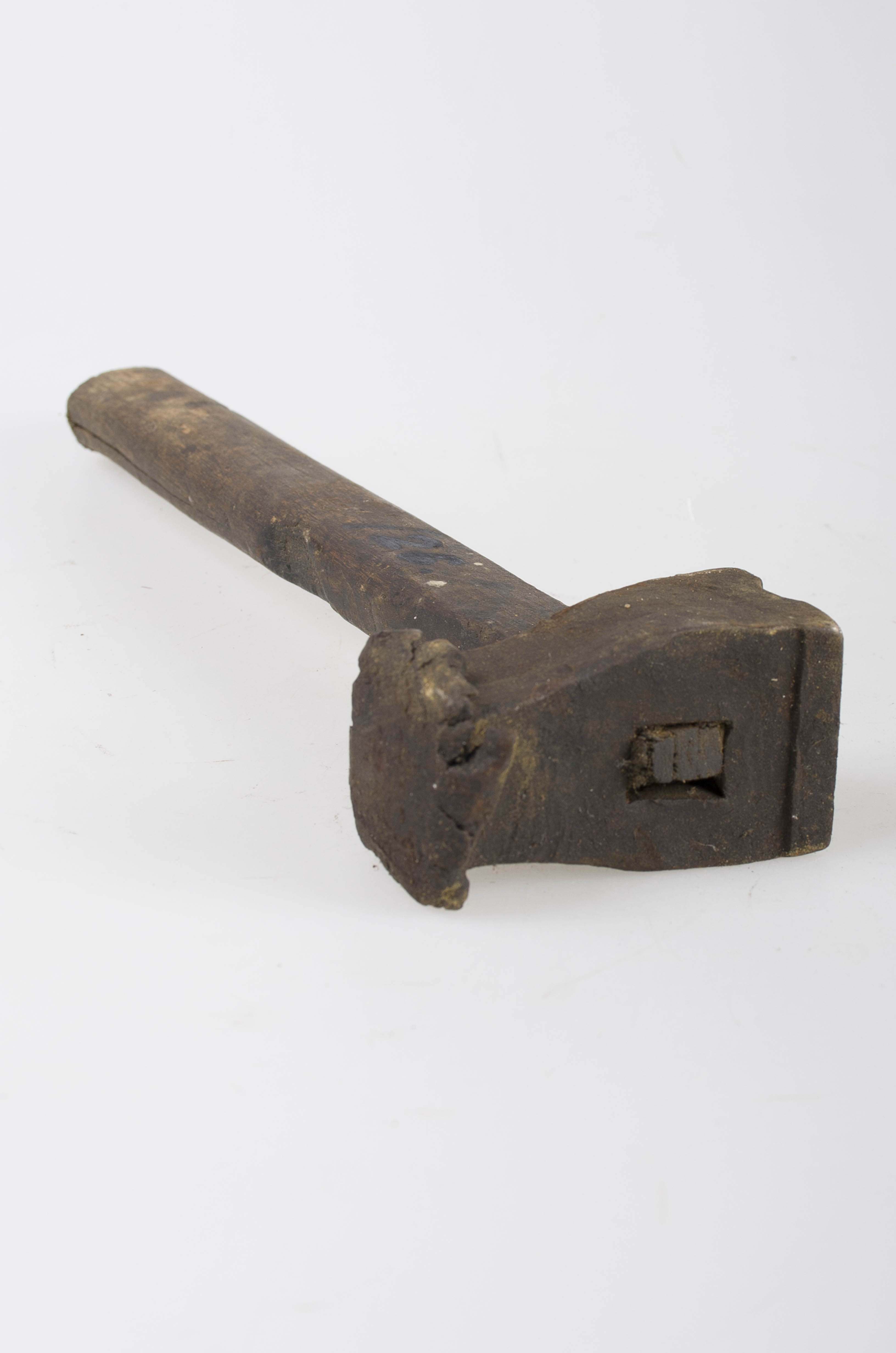 Piesa are formă de „T” realizat din două materiale diferite, reprezentând un ciocan. Partea de batere este realizat din metal și are două laturi de acțiune, iar partea de prindere este realizată din lemn. Partea de batere este de formă paralelipipedică, una din laturile înguste fiind ușor conică și prezentând o „floare” obținută de la batere intensă, iar cealaltă latură este mai lată și are o scobitură semicirculară. La 2/3 spre partea mai lată se află o gaură de înmănușare în care este fixată coada care are 35 cm lungime. Cromatică: culoarea patinată a lemnului; negru.