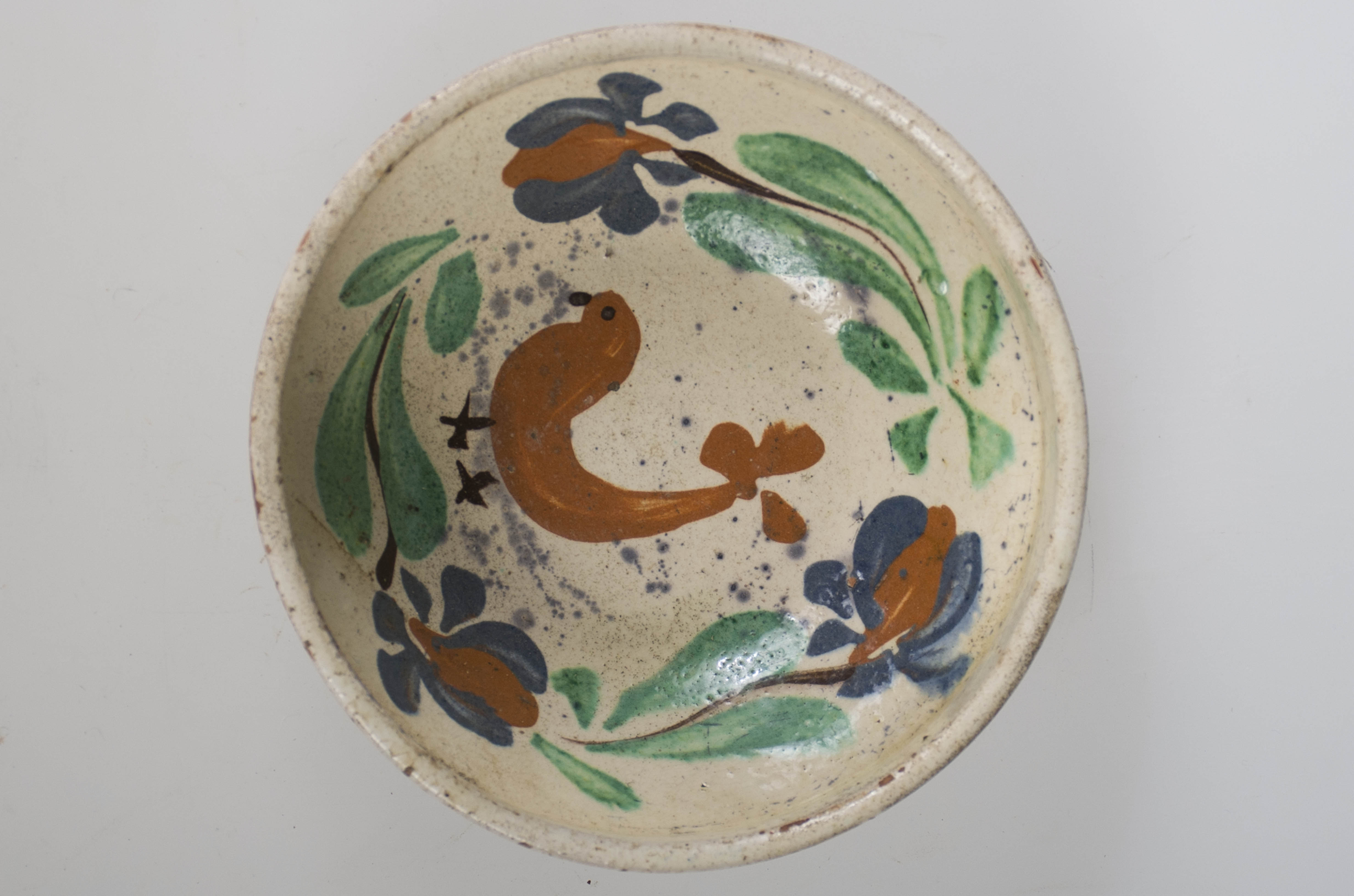 Blidul de formă tronconică este adânc, smălțuit la interior. Vasul este ornamentat cu motive florale și avimorfe, cu buza înaltă, neornamentat și nesmălțuit la exterior. Cromatică: fond: maro-roșcat (exterior); alb (interior); decor: verde; maro; albastru; negru.