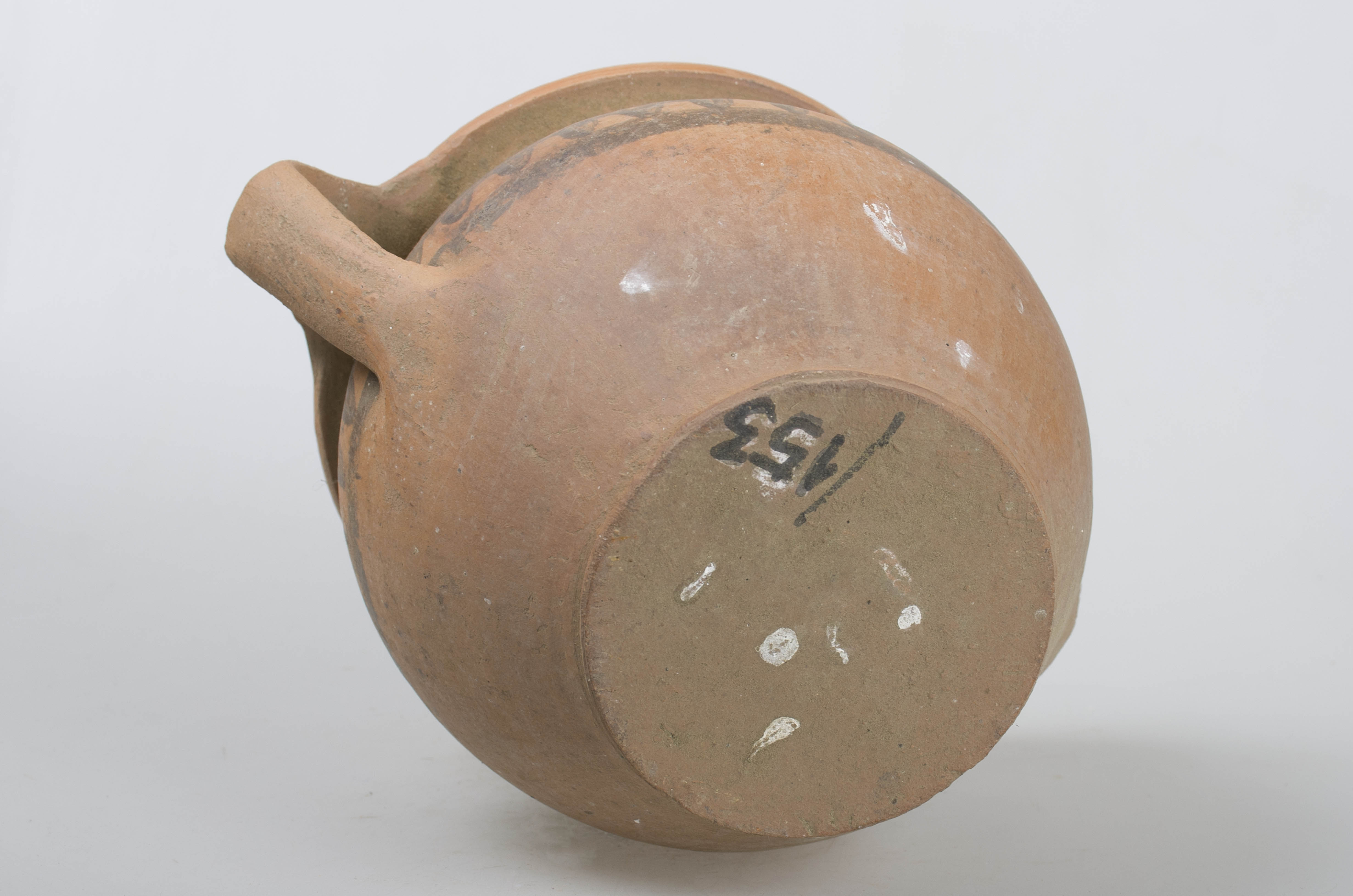 Vas ceramic sferoidal, bombat în partea mediană cu gât larg și scurt, gura având marginile răsfrânte spre exterior, prezintă două toarte simetric laterale, ce leagă gura cu partea de diametru maxim a vasului. Ornamentații în partea superioară a ulciorului ilustrând motivul dintelui de lup, specific centrului ceramic Săcel, dispus în alternanță pe ambele părți a unei linii continue incizate dispuse circular, încadrată de două dungi negre. Cromatică: cărămiziu; negru.