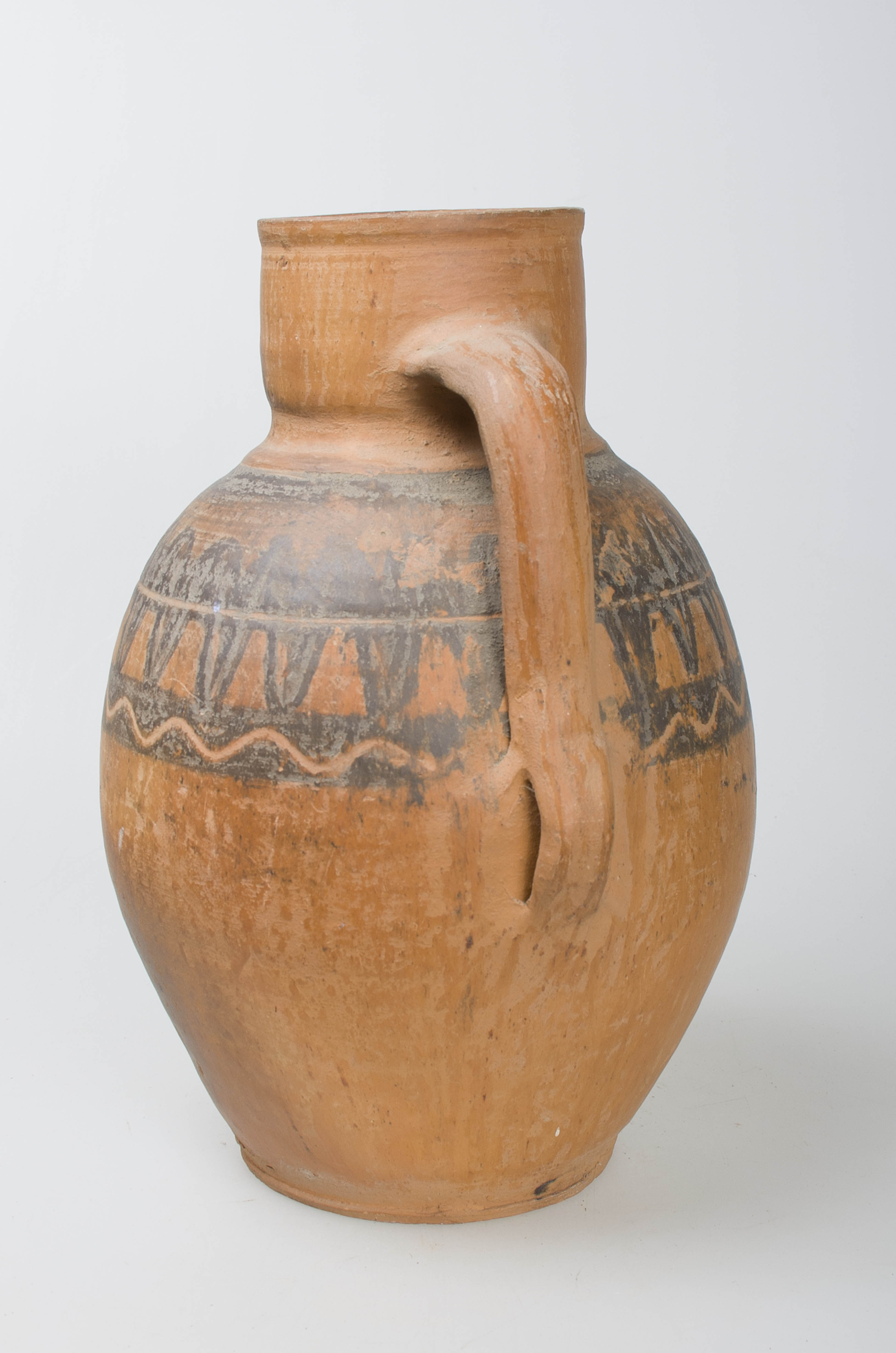 Vas ceramic sferoidal, gât larg și cilindric terminat cu o gură circulară și buză dreaptă, prezintă o toartă ce unește baza gâtului cu partea de diametru maxim a vasului. Ornamentații în partea superioară a ulciorului ilustrând motivul dintelui de lup, specific centrului ceramic Săcel, dispus în alternanță pe ambele părți a unei linii continue incizate dispuse circular, încadrată de două dungi negre, peste cea din partea inferioară fiind suprapusă o linie ondulată. Peste registrul decorativ principal se suprapun ușoare incizii ce urmează linia decorației centrale. Creomatică: cărămiziu; negru.