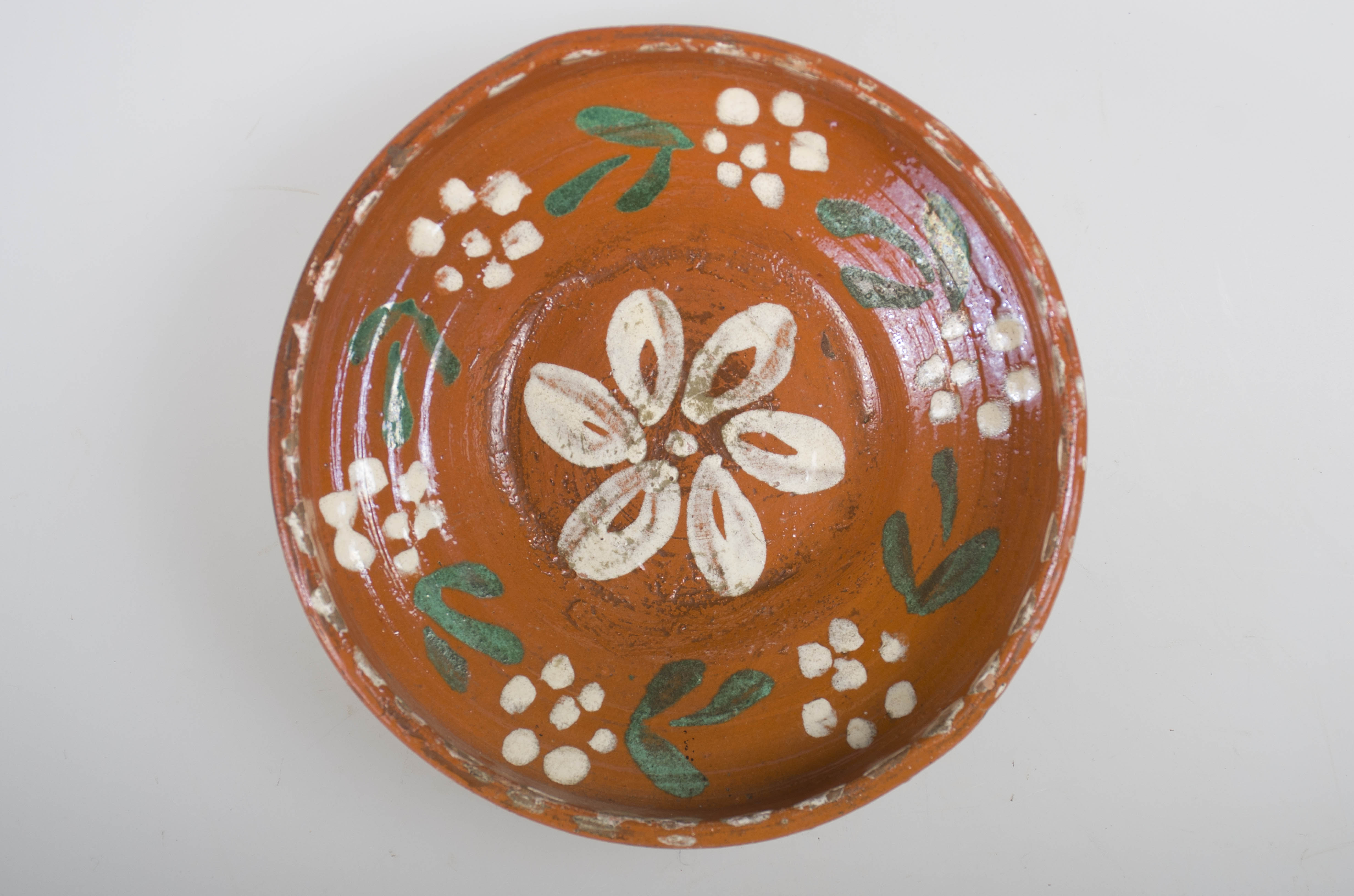 Blidul de formă tronconică este unul adânc, smălțuit pe interior. Acesta prezintă ornamente cu motive florale și linii punctate, având buza înaltă. Nu este ornamentat la exterior. Obiectul este smălțuit la exterior doar pe buză. Acesta prezintă puncte pictate cu pensula pe buză, la interior. Fundul vasului are formă circulară, fiind prevăzut cu două orificii pentru prindere. Cromatică: fond: cărămiziu; decor: alb; verde.