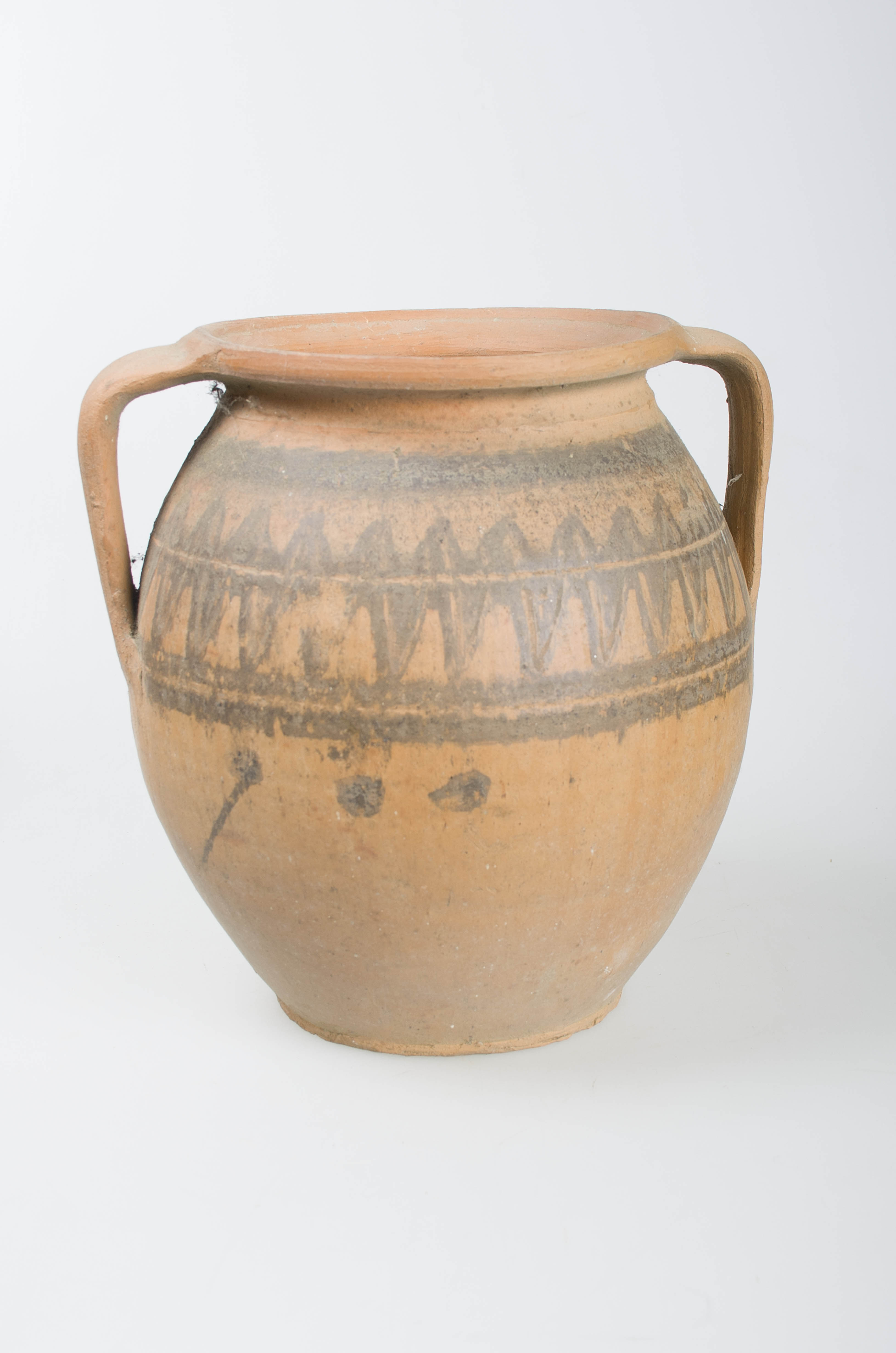 Vas ceramic de formă sferoidală, bombat în partea mediană, cu gât scurt și larg, buză dreaptă. Vasul prezintă două toarte ce leagă gura cu partea de diametru maxim a vasului. Prezintă ornamentații în partea superioară a oalei ilustrând motivul dintelui de lup, specific centrului ceramic Săcel, dispus în alternanță pe ambele părți a unei linii continue incizate dispuse circular, încadrată de două dungi negre. Cromatică: cărămiziu; negru.