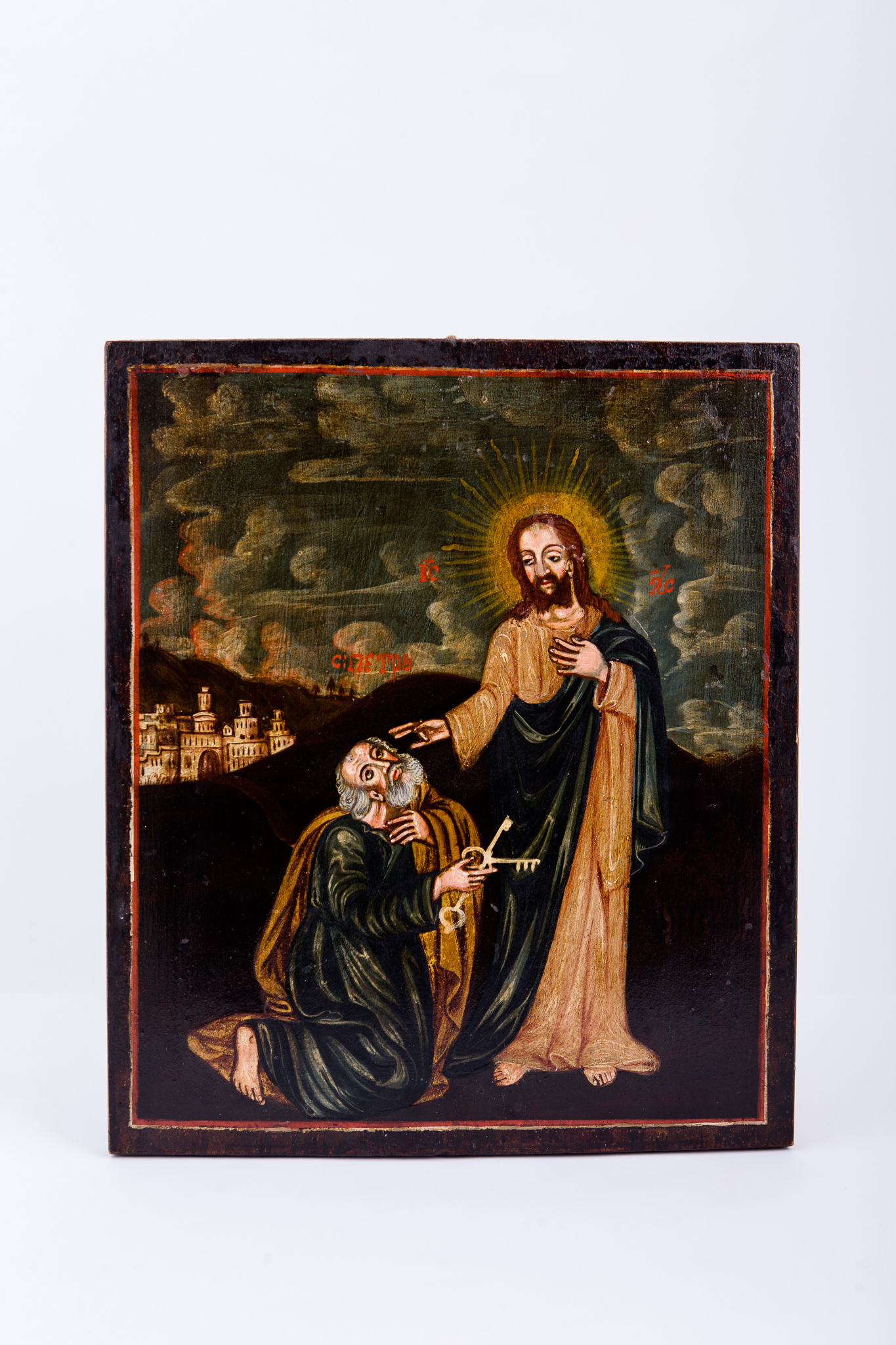 Mântuitorul Iisus Hristos, îmbrăcat în sacos lung galben-crem-bej, cu mantie verde, pe umăr, cu aureolă din raze de lumină, atinge cu mângâiere, ocrotire și Binecuvântare creștetul și umerii Sfântului Apostol Petru, care stă îngenuncheat în fața Domnului. Sfântul Petru este îmbrăcat în sacos verde, cu mantie galbenă-bronzie, primind cheile Împărăției Raiului. Simon Petru, fratele Sfântului Apostol Andrei, pescar evreu din Betsaida, este unul dintre primii discipoli ai Mântuitorului. Sfântul Petru a fost unul dintre cei mai apropiați ucenici și apostoli. În registrul superior, este cerul verde-kaki, cu nouri învolburați, cu striații mici roșii, ca de amurg. În registrul inferior sunt dealuri brune-cafenii, iar în registrul îndepărtat se văd zidurile caselor cetății Ierusalimului. Pictura este încadrată de un chenar liniar roșu-vermillon. Cromatica este autumnală, vernisată, barocă: brun-cafeniu, ocru, bej, crem, verde de China, negru. Inscripția din româno-chirilică se traduce IC XC Iisus Hristos Sf Petru.