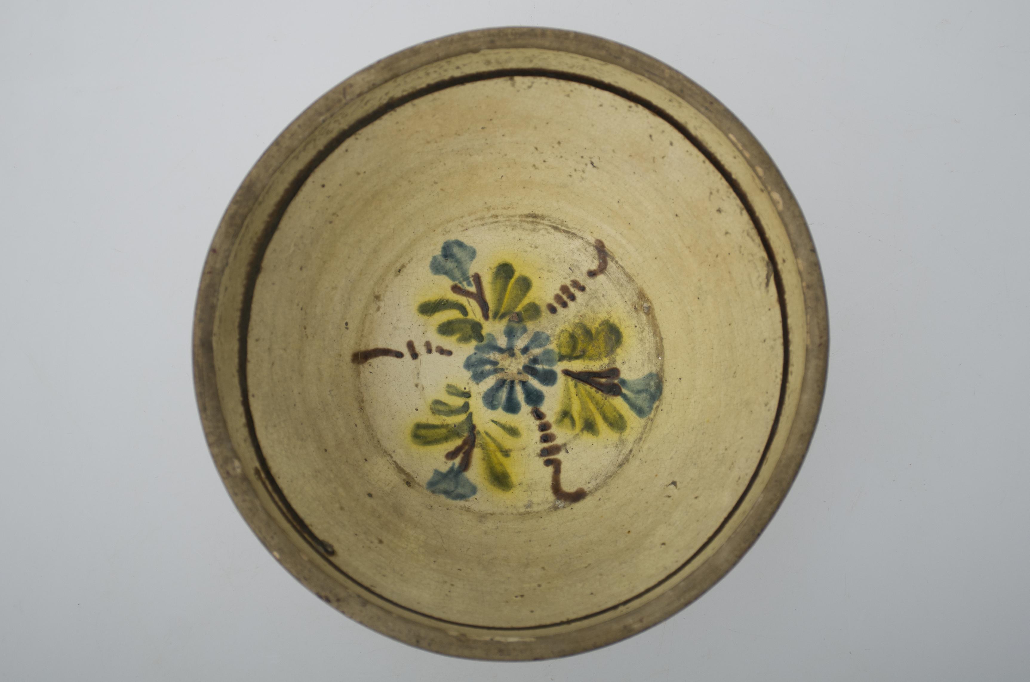 Strachină adâncă de formă tronconică, cu pereții oblici curbați; este smălțuită numai în interior; central motiv floral. Cromatică: fond: alb; motive: brun; verde; albastru; galben.