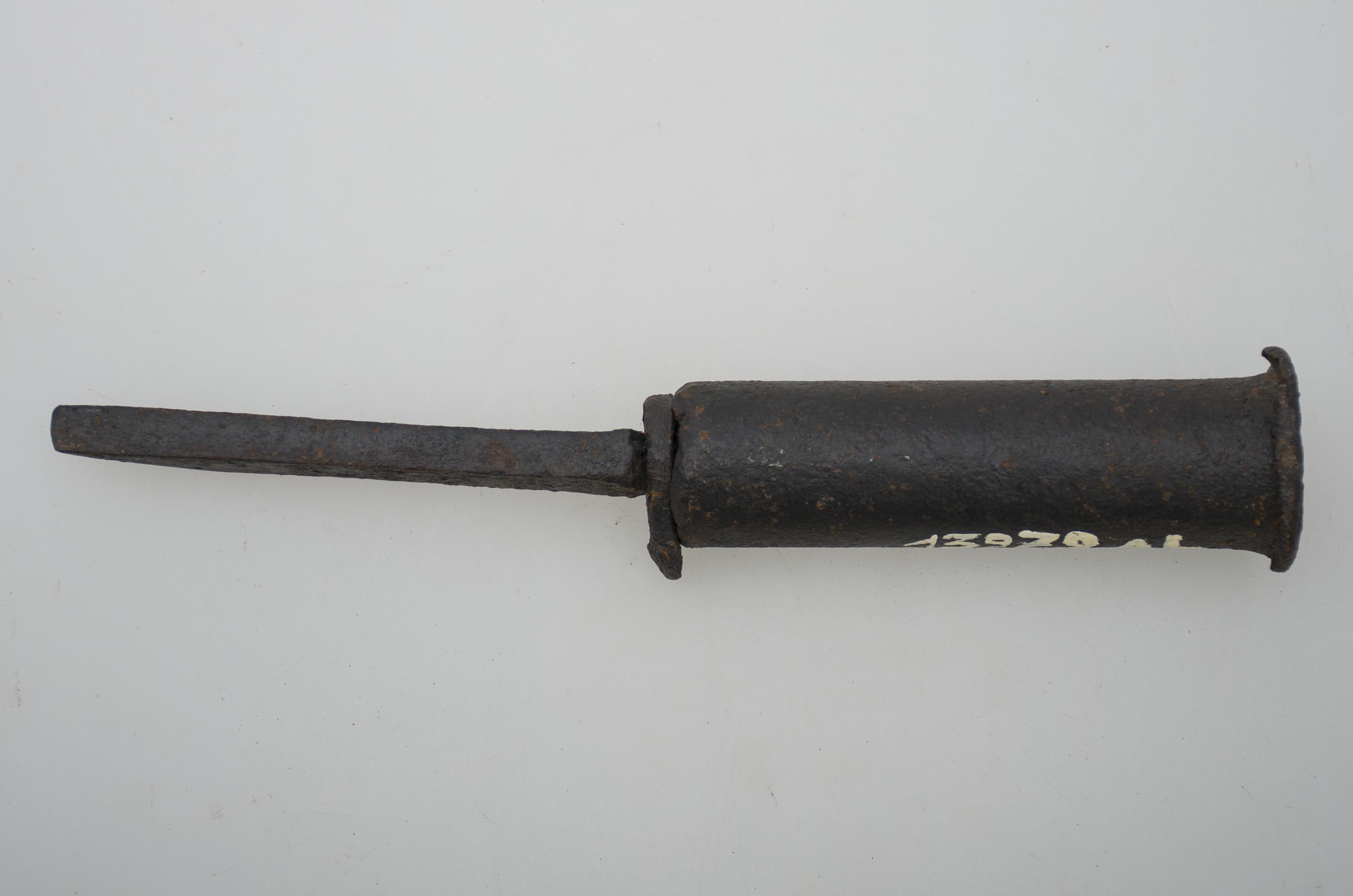 Unealta este confecționată din metal, având corpul format dintr-o tijă metalică cilindrică de care este sudată o platbandă tăiată oblic unul dintre capete. Cromatică: culoarea metalului.