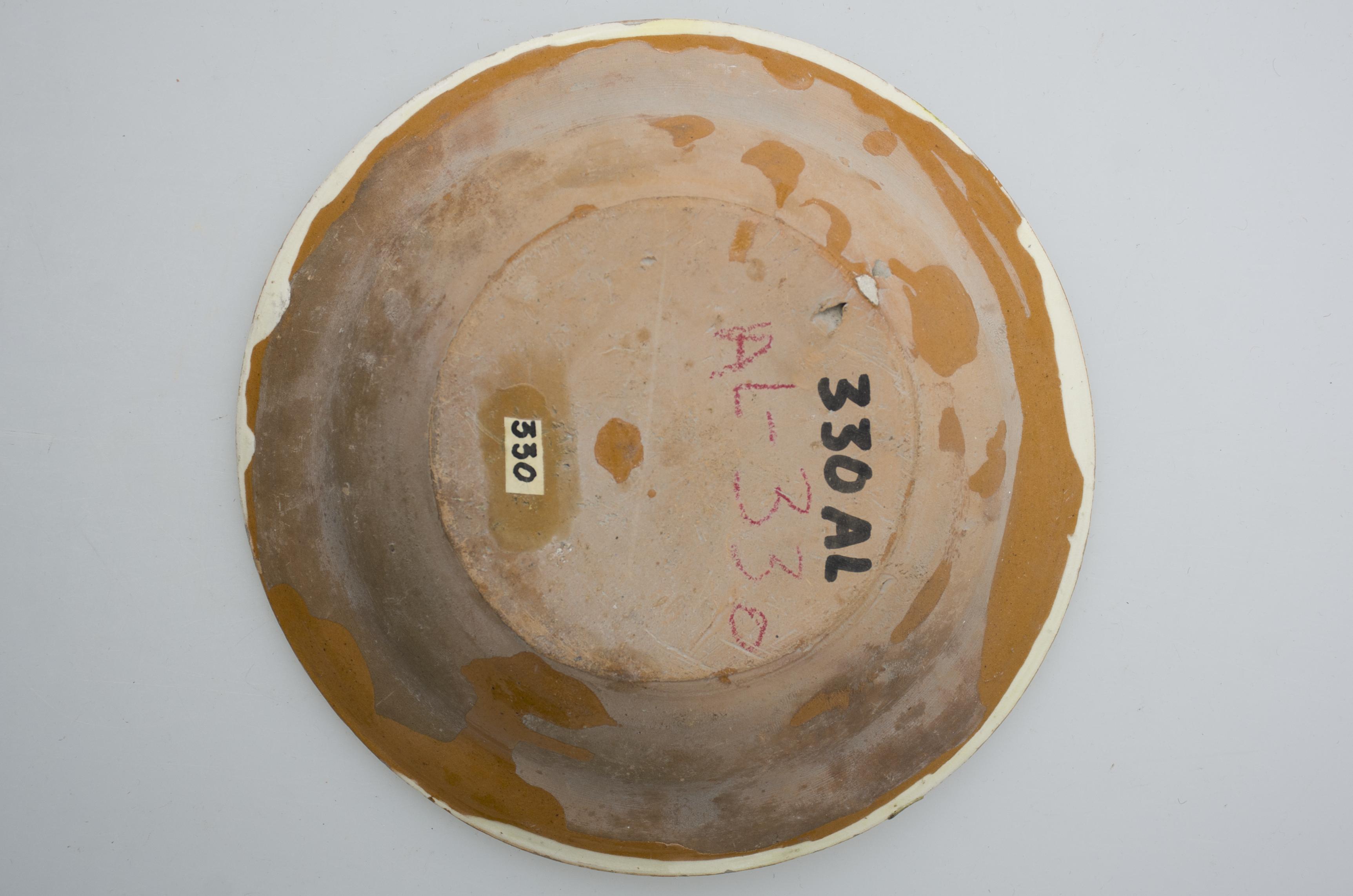 Vas ceramic smălțuit în interior, de formă circulară și profil tronconic, cu marginile puțin evazate și fundul plat. Pe fond gălbui, vasul este decorat cu motive vegetal-florale dispuse paralel, pe pereți: două flori lunguiețe cu mai multe rânnduri de frunze, multicolore. Prezintă urme de uzură funcțională. Cromatică: fond: gălbui; motive: maro, verde, cărămiziu, galben.