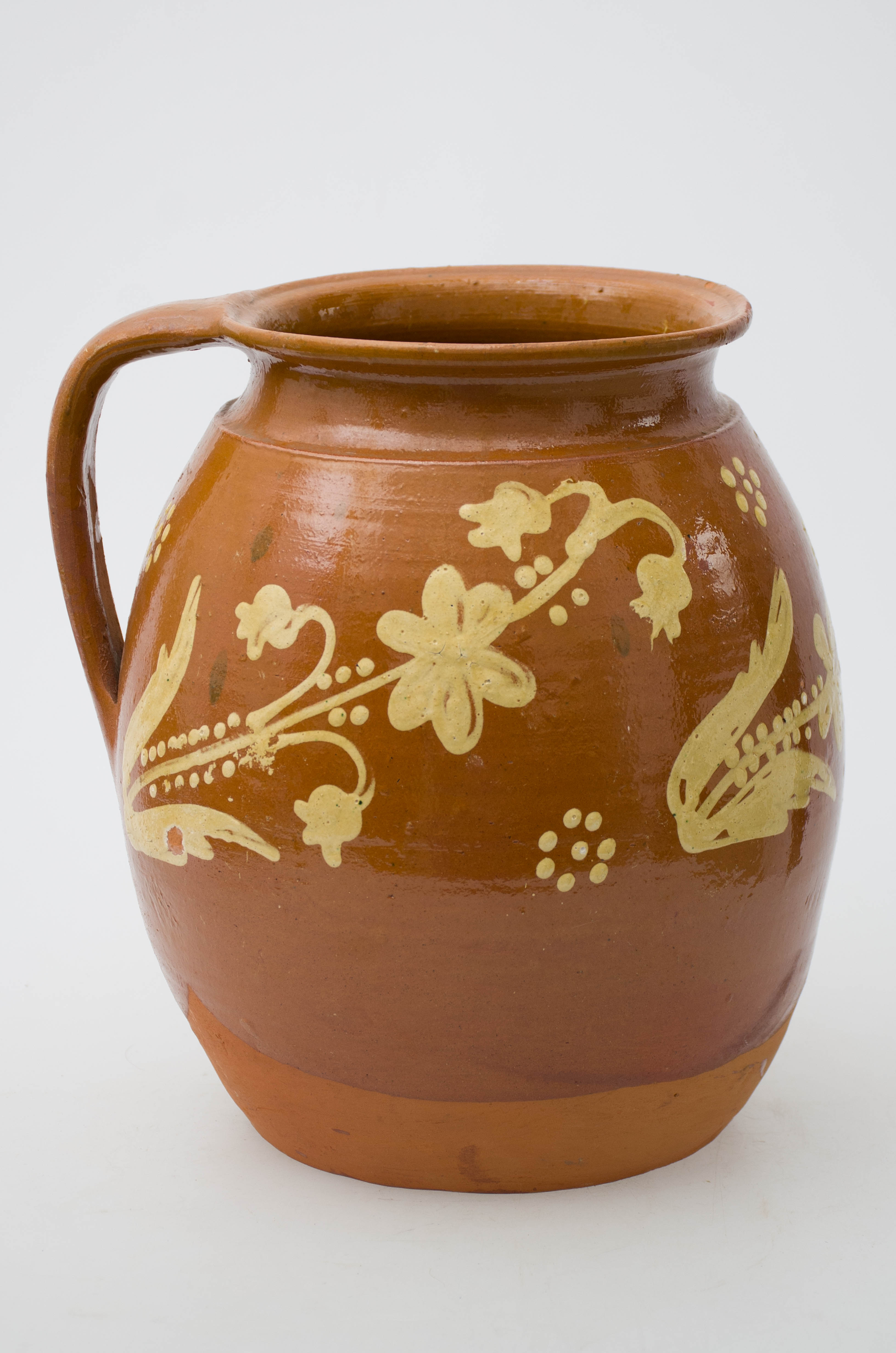Vasul ceramic este smălțuit, având formă ovoidală, fiind bombat, cu gâtul scurt și buza ușor răsfrântă și rotunjtă. Acesta este prevăzut cu o toartă lată cu punctele de inserție în buză și zona mediană a vasului. În partea superioară, piesa este ornamentată cu trei registre florale, pictate cu galben. Vasul este smălțuit integral la interior, iar la exterior până spre fundul vasului. Cromatică: fond: cărămiziu; motive: galben.