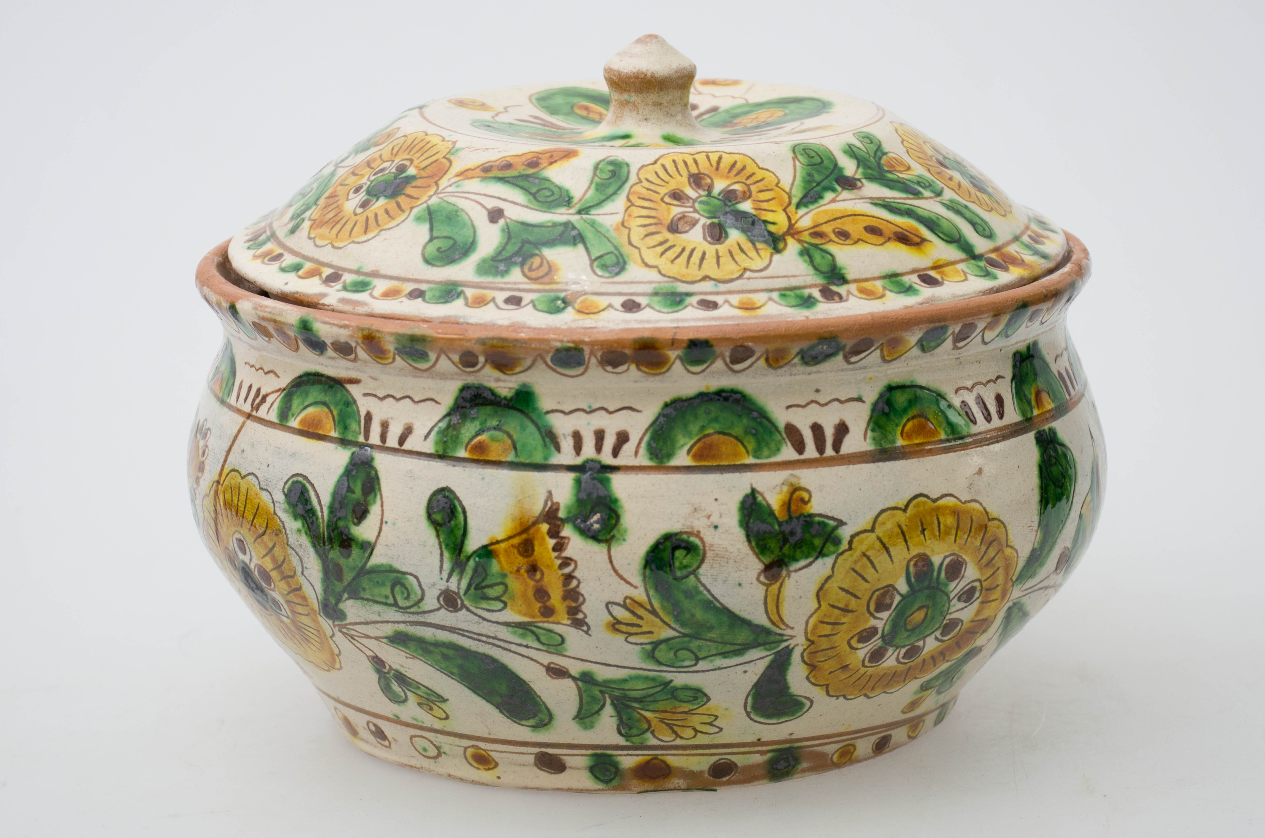 Vas ceramic smălțuit de formă sferică, cu gâtul scurt și buza reliefată și rotunjtă. Vasul este intens stilizat cu motive incizate și mai apoi pictate vegetal-florale și geometrice: un șir de puncte în semicercuri la buză, cunună de flori în zona mediană iar spre fundul vasului, un șir de puncte pictate verde, maro și galben, alternativ. Registrele sunt separate între ele cu linii subțiri circulare, pictate cu maro. Vasul este prevăzut cu capac, ornamentat cu același model de pe vas. Capacul este prevăzut cu un bumb circular, pentru prindere. Pe fundul vasului este incizat numele meșterului olar, Colibaba. Cromatică: fond exterior: alb, fond interior: maro; motive: maro, galben, negru.