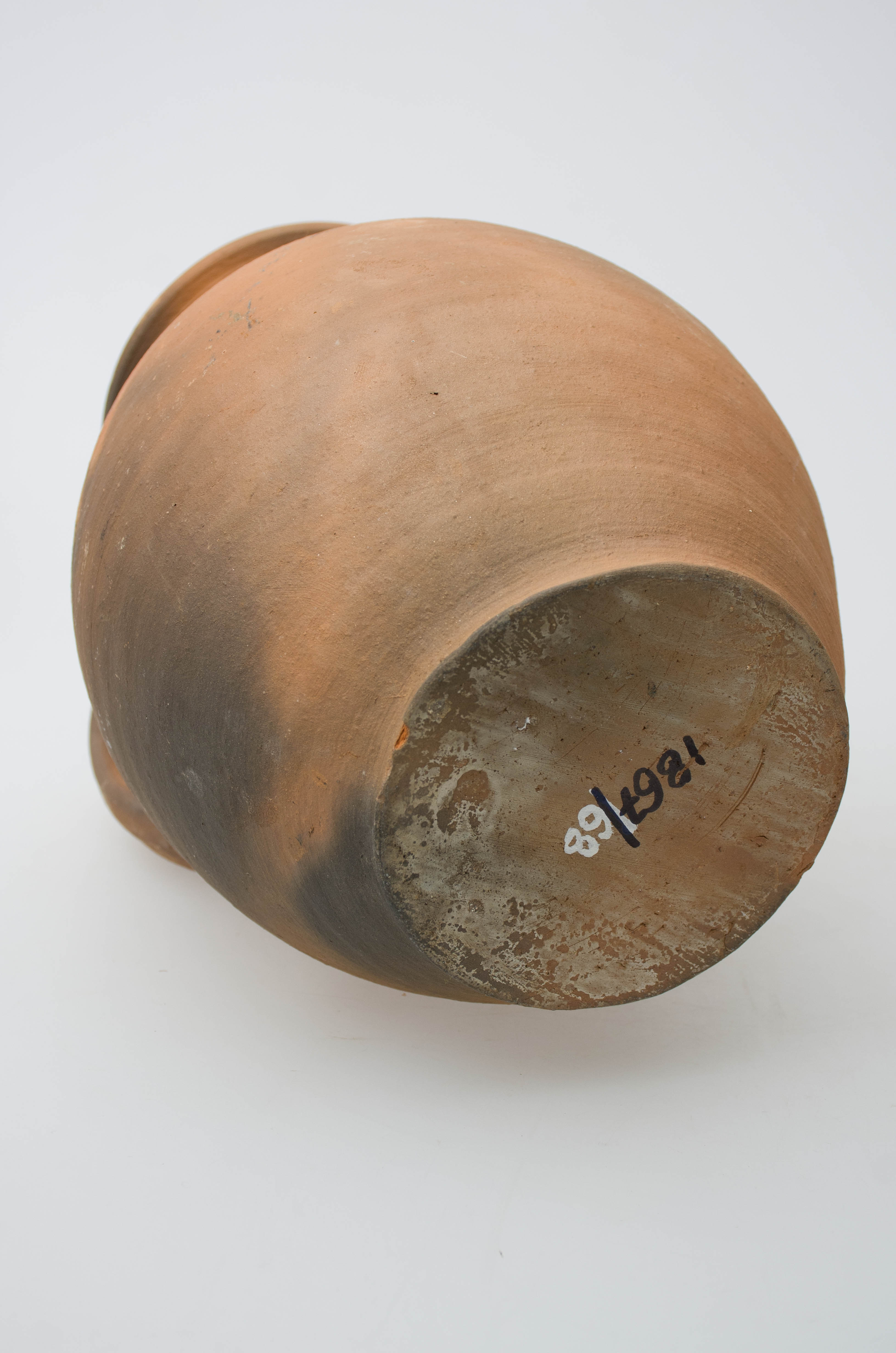 Vasul ceramic este nesmălțuit, având formă ovoidală, cu gâtul scurt și buza ușor evazată și răsfrântă în exterior. Obiectul este prevăzut cu o toartă lată și arcuită care pleacă din buză și se termină în zona mediană a recipientului. Acesta este decorat cu motive geometrice pe umeri, lucrate cu humă albă: ondulații digitale și dungi realizate cu ficheșul. Pe toartă este stropit cu pete neregulate. Obiectul prezintă urme de uzură funcțională. Cromatică: fond: cărămiziu; motive: alb.