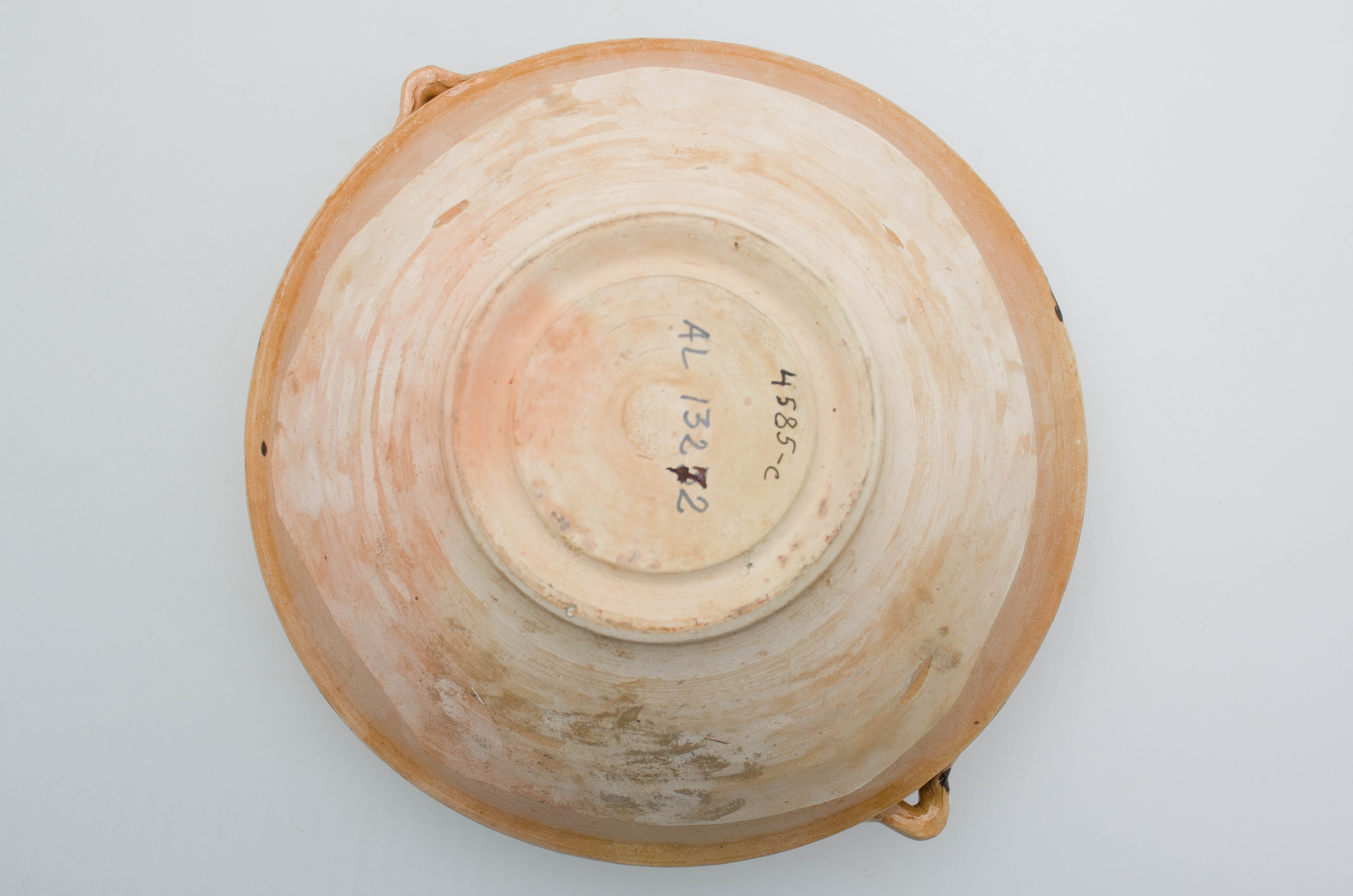 Vasul ceramic are formă tronconică, fiind prevăzut cu pereți înalți și buza dreaptă. Obiectul prezintă două tortițe sub forma literei V dispuse lateral, prinse de buză și de umerii vasului. Vasul este ornamentat atât la interior cât și la exterior cu motive geometrice și vegetal-florale, realizate prin jirăvire și pictare cu pensula. La interior, între cele trei șiruri jiravite, piesa este decorată cu o linie ondulată încadrată de boboci de floare, de un șir de puncte, și de crenguțe și flori. La exterior, pe buză, este pictată o linie șerpuită de o parte și de alta fiind boboci de floare sub forma literei V. Piesa este smălțuită la exterior. Cromatică: fond exterior: cărămiziu; fond interior: maro; motive: alb, verde, cărămiziu.