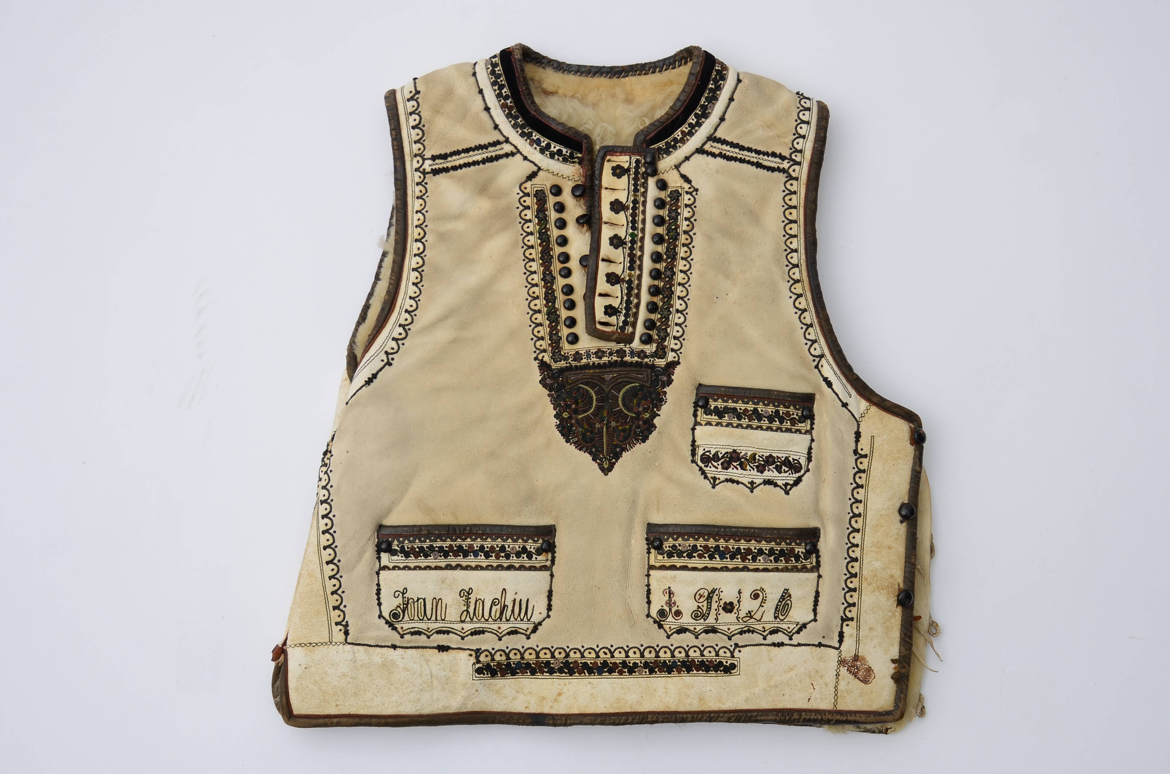 Pieptarul bărbătesc este prevăzut cu deschizătură în partea stângă, fiind prevăzut cu o broderie de bumbac, trei buzunare aplicate prin coasere pe față. Decorul este constituit din motive geometrice: puncte, linii drepte, linii curbe și motive florale. Obiectul este brodat în zona buzunarelor, în zona gulerului și pe margine. Garnitura de la gât este realizată din postav negru, aceasta încheindu-se la guler cu 6 nasturi. Alți 22 nasturi negri sunt așezați pe două linii paralele cu nasturii de încheiere ai gulerului. Obiectul este brodat pe buzunare cu numele proprietarului și anul: Ioan Zachiu și 1926. Cromatica: fond alb, motive: verde, maro, negru, albastru.